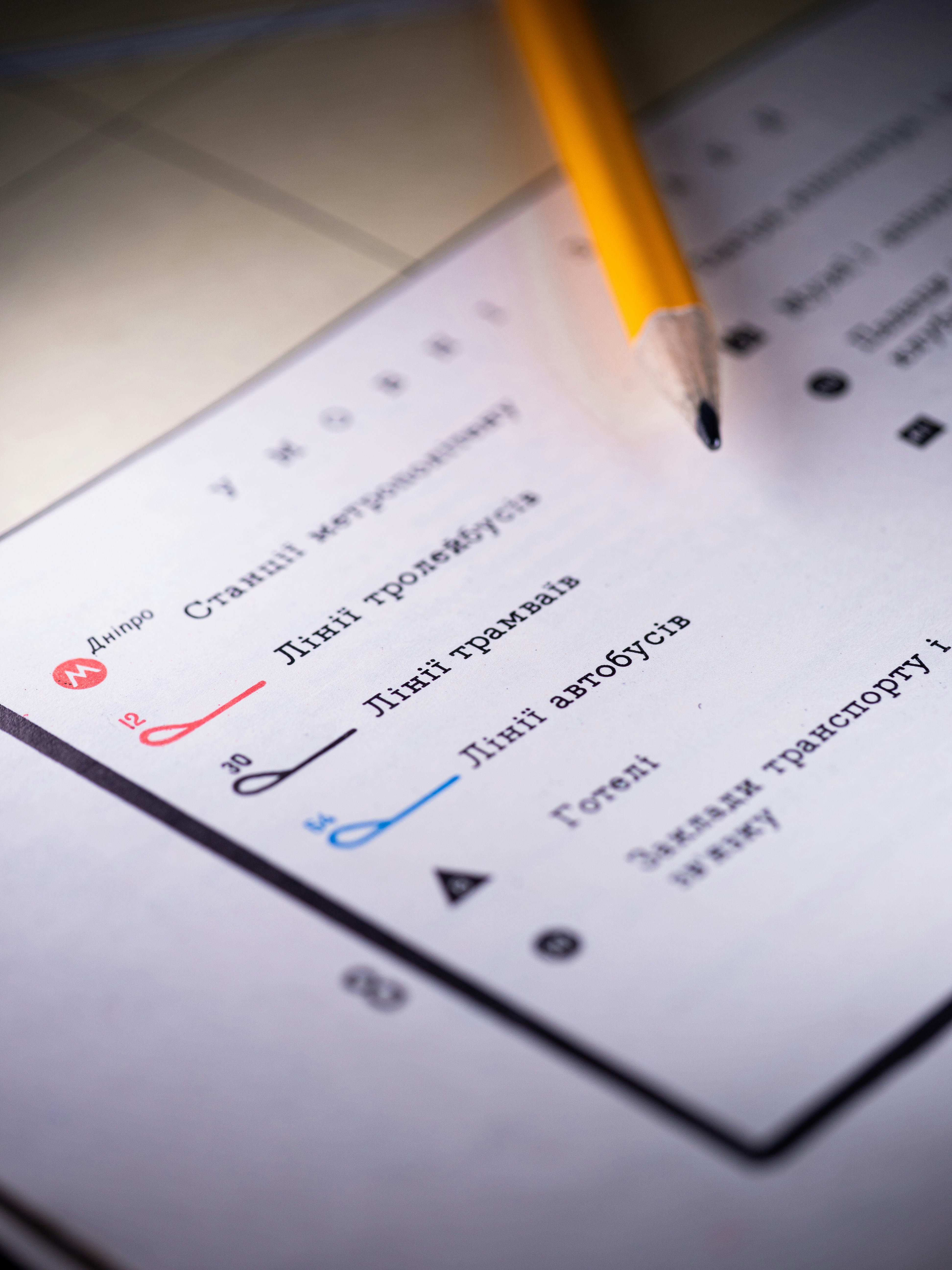 O lápis repousa sobre um mapa detalhado com linhas de transporte.