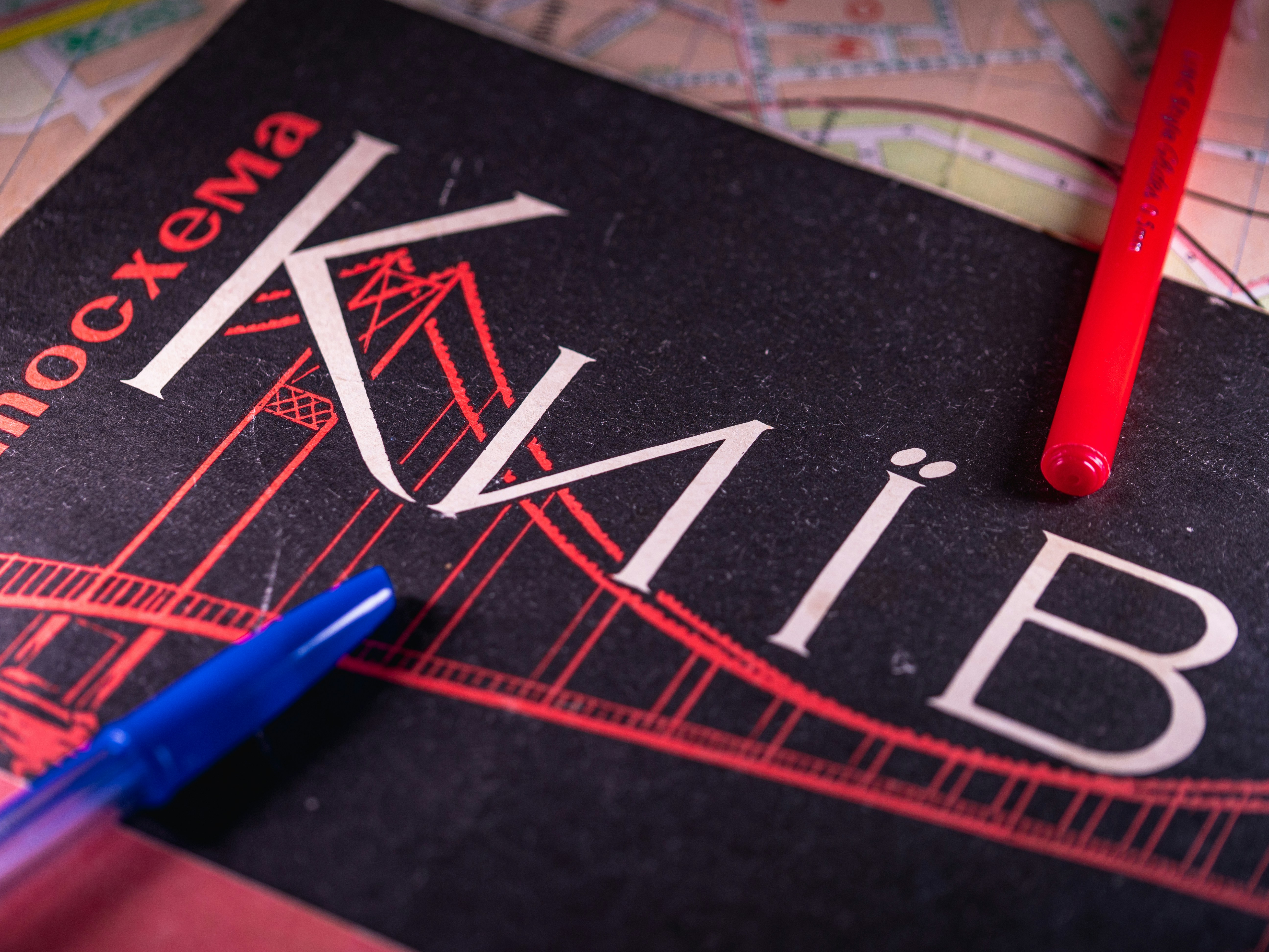 Kyiv guidebook with pens on a map.