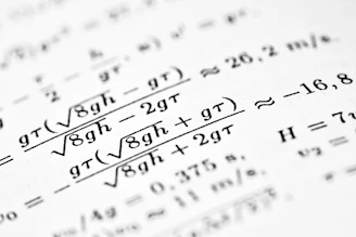 Mathematical formulas are written on a white sheet of paper.