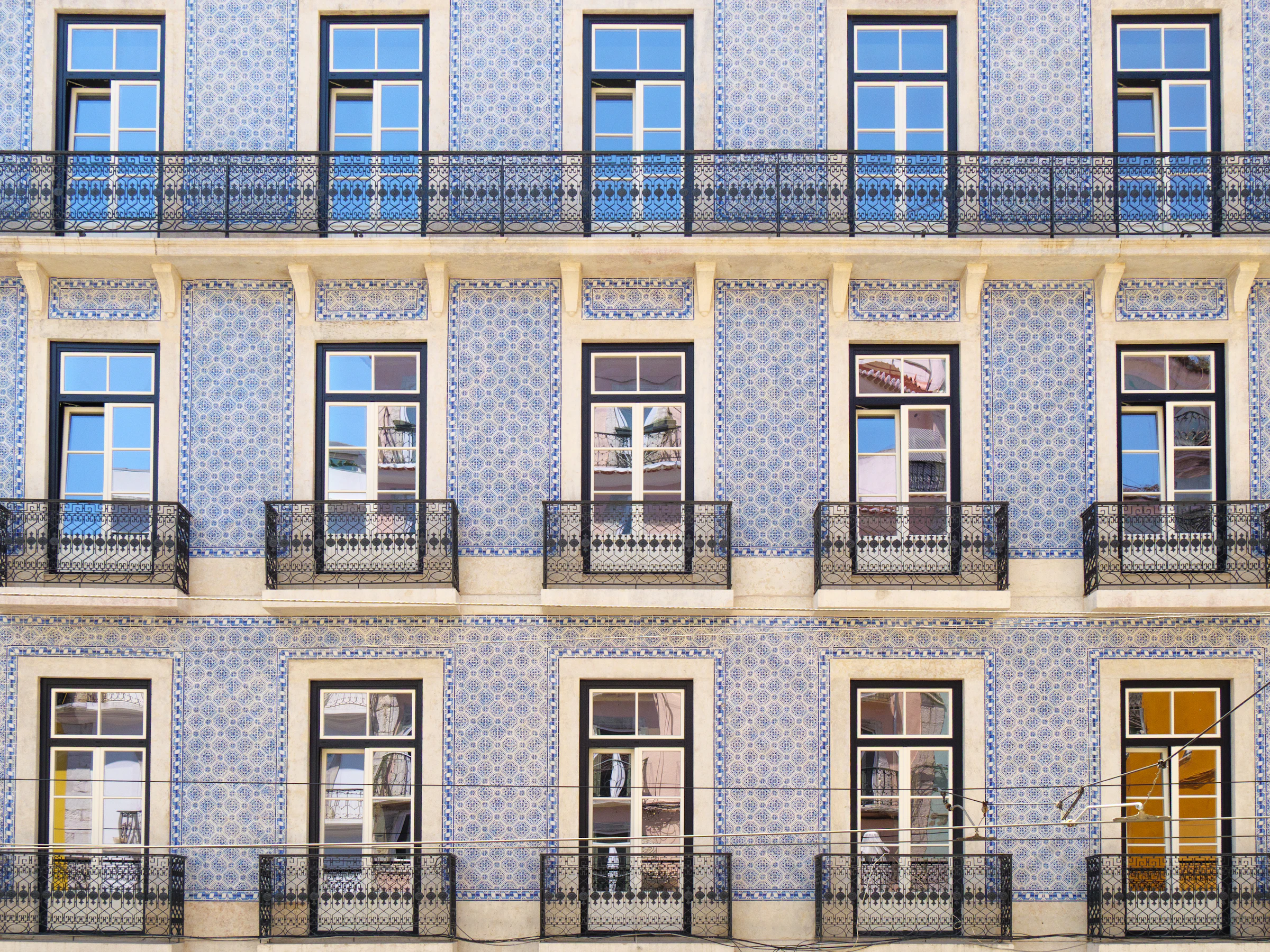Fachada de azulejo azul com varandas de ferro em Lisboa