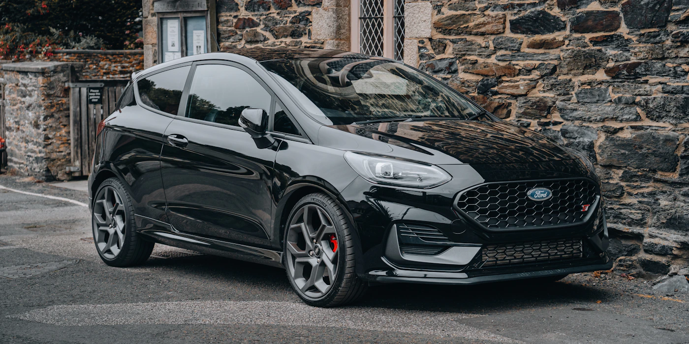 Black Ford parked in front of a wall