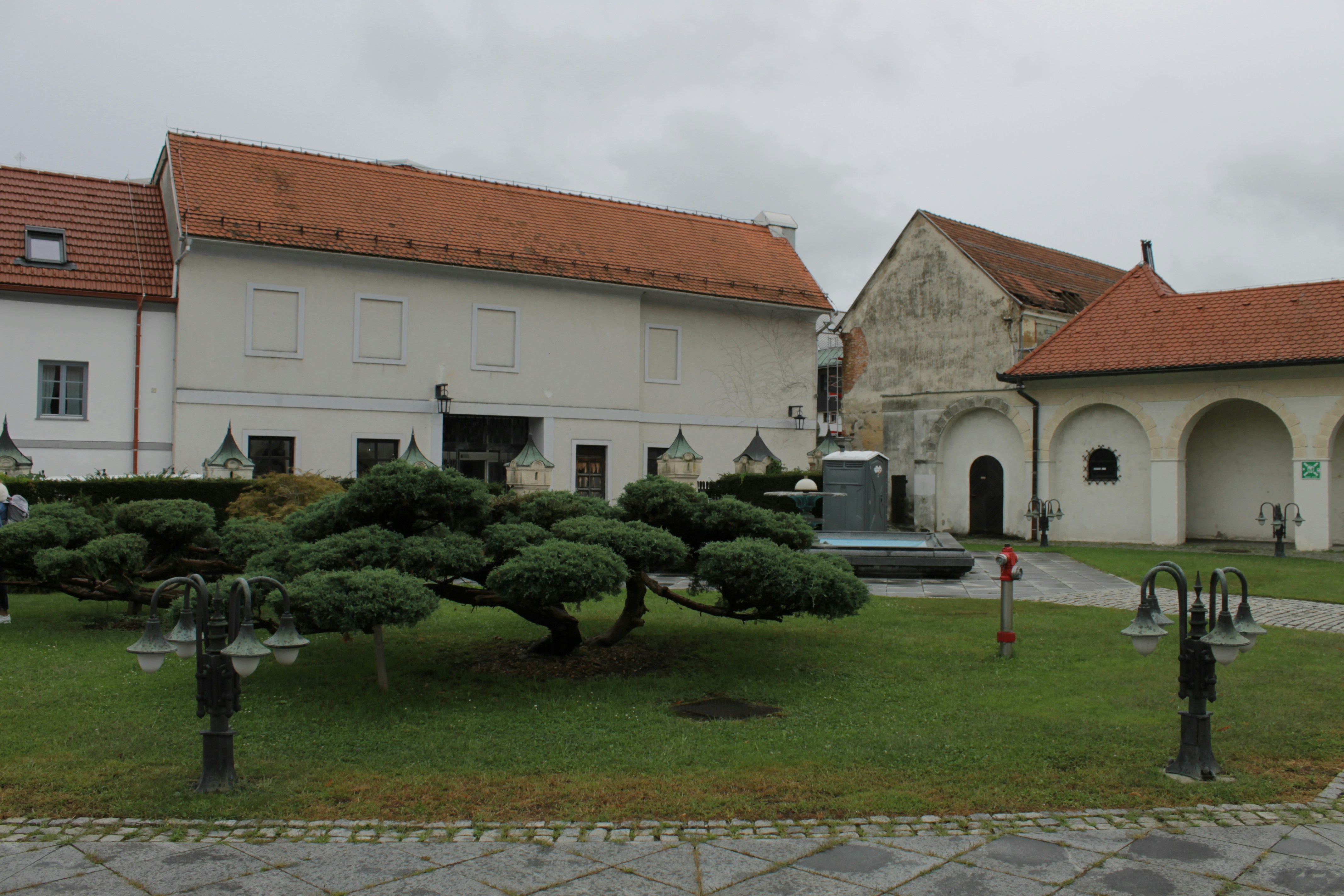 Buildings with red roofs surround a plaza.