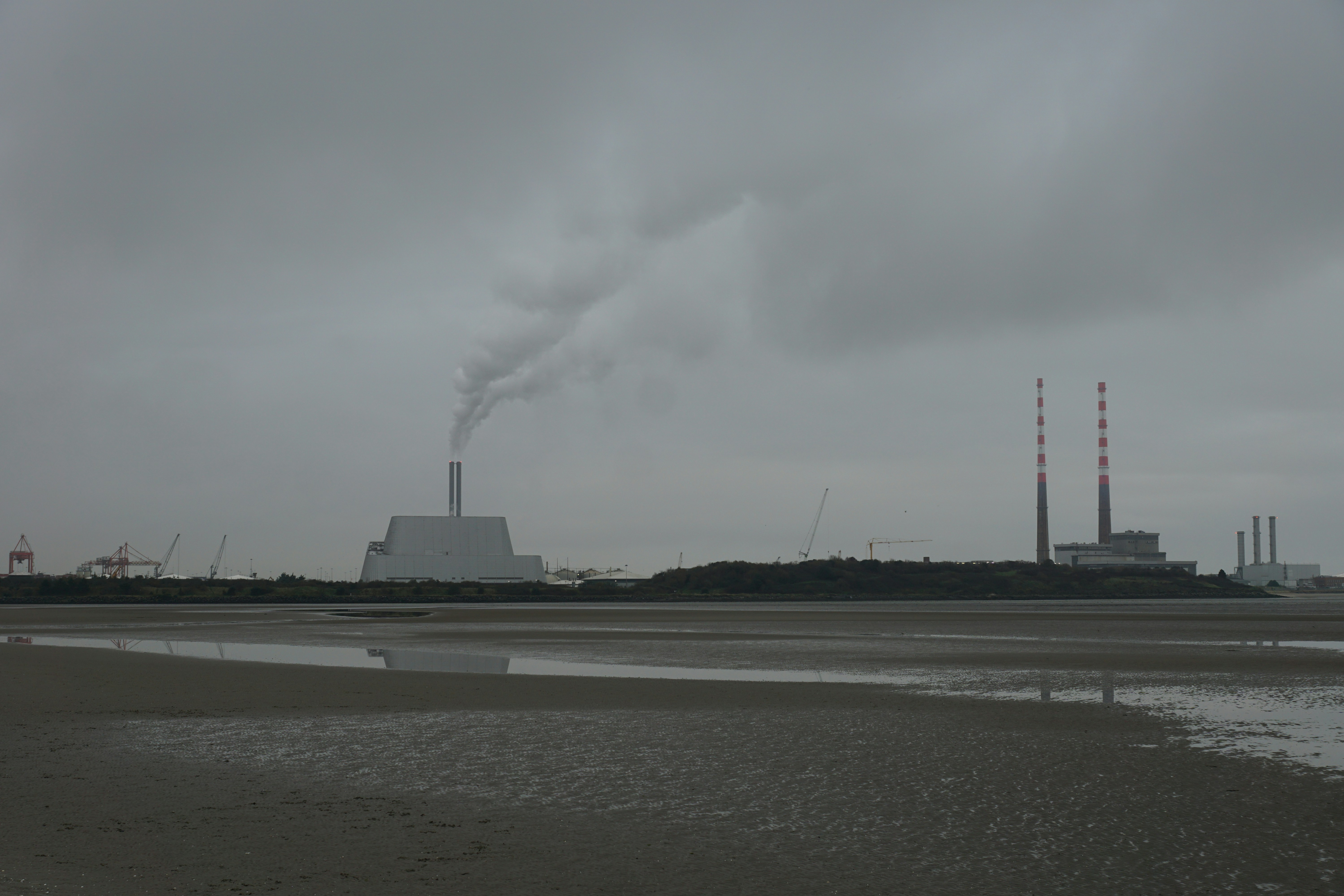 Smokestacks and power plants on a cloudy day.