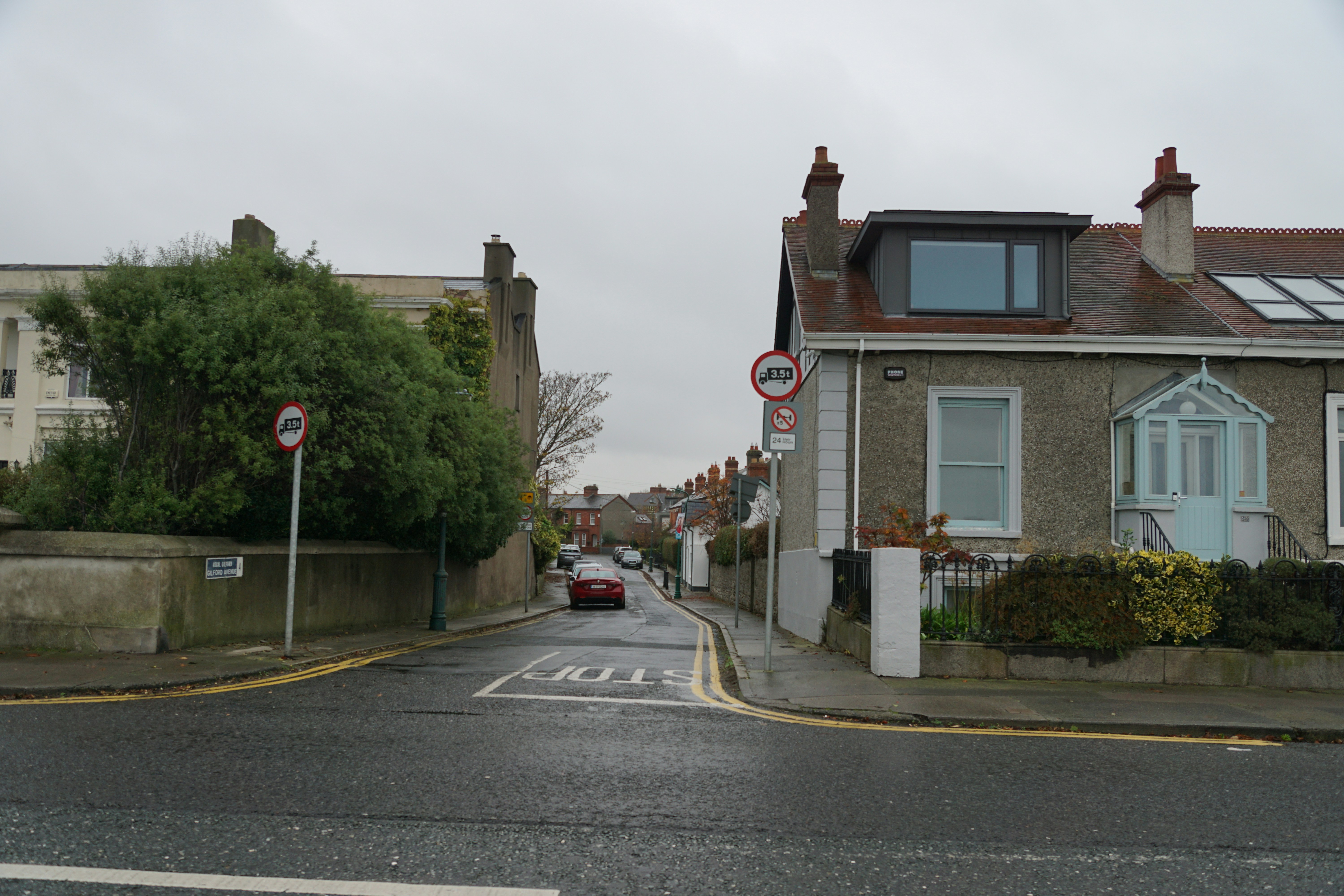 A residential street with houses and a car.