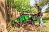 A worker operates a tree stump grinder.