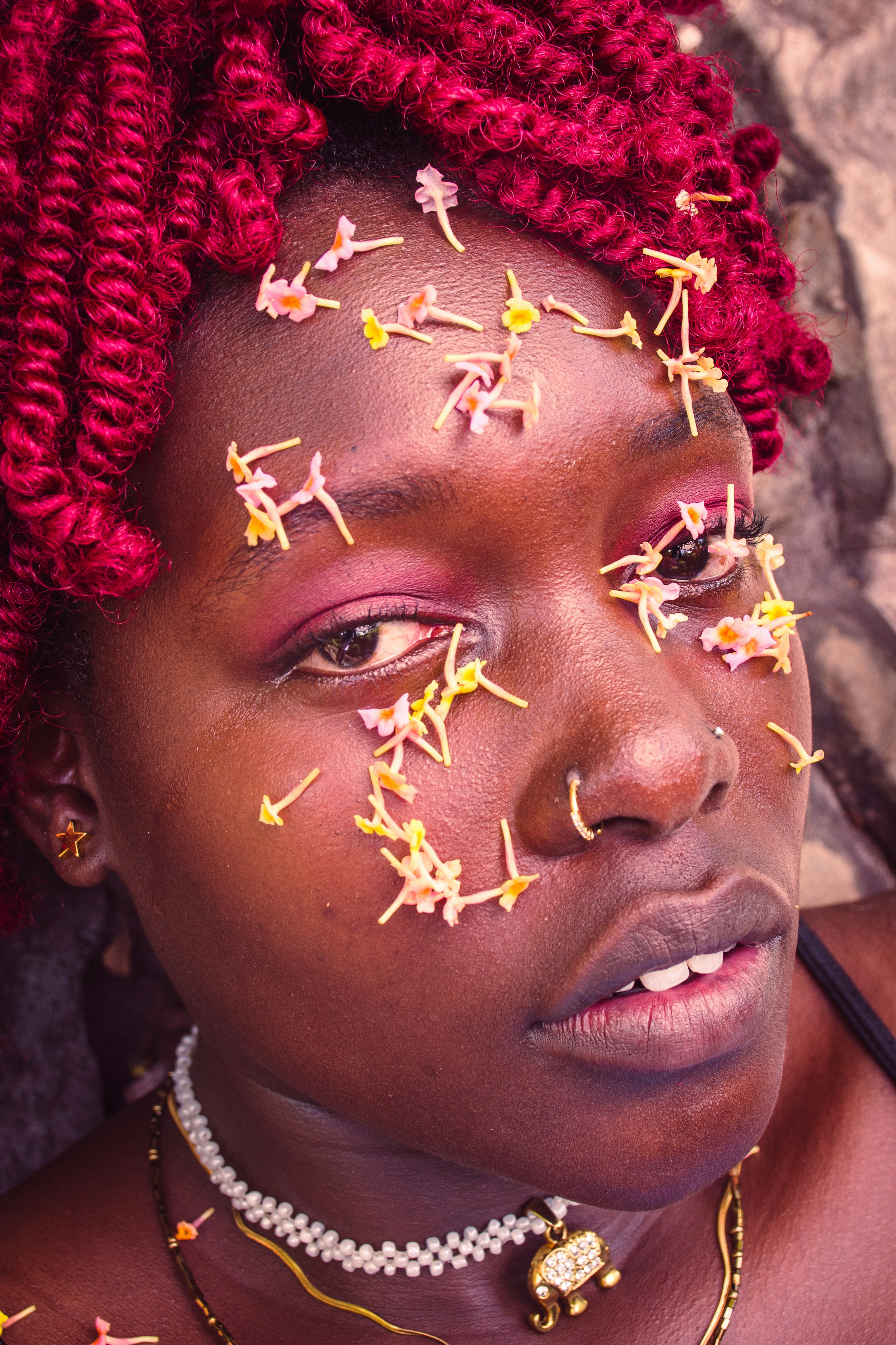Woman with flowers on her face and red hair.