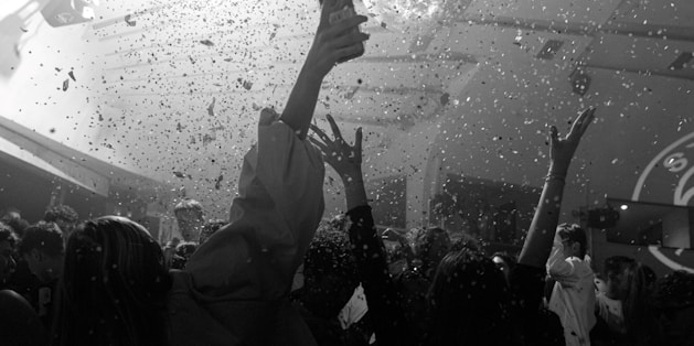 People dance at a party with confetti.