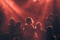 People dance in a smoky room with red lighting.
