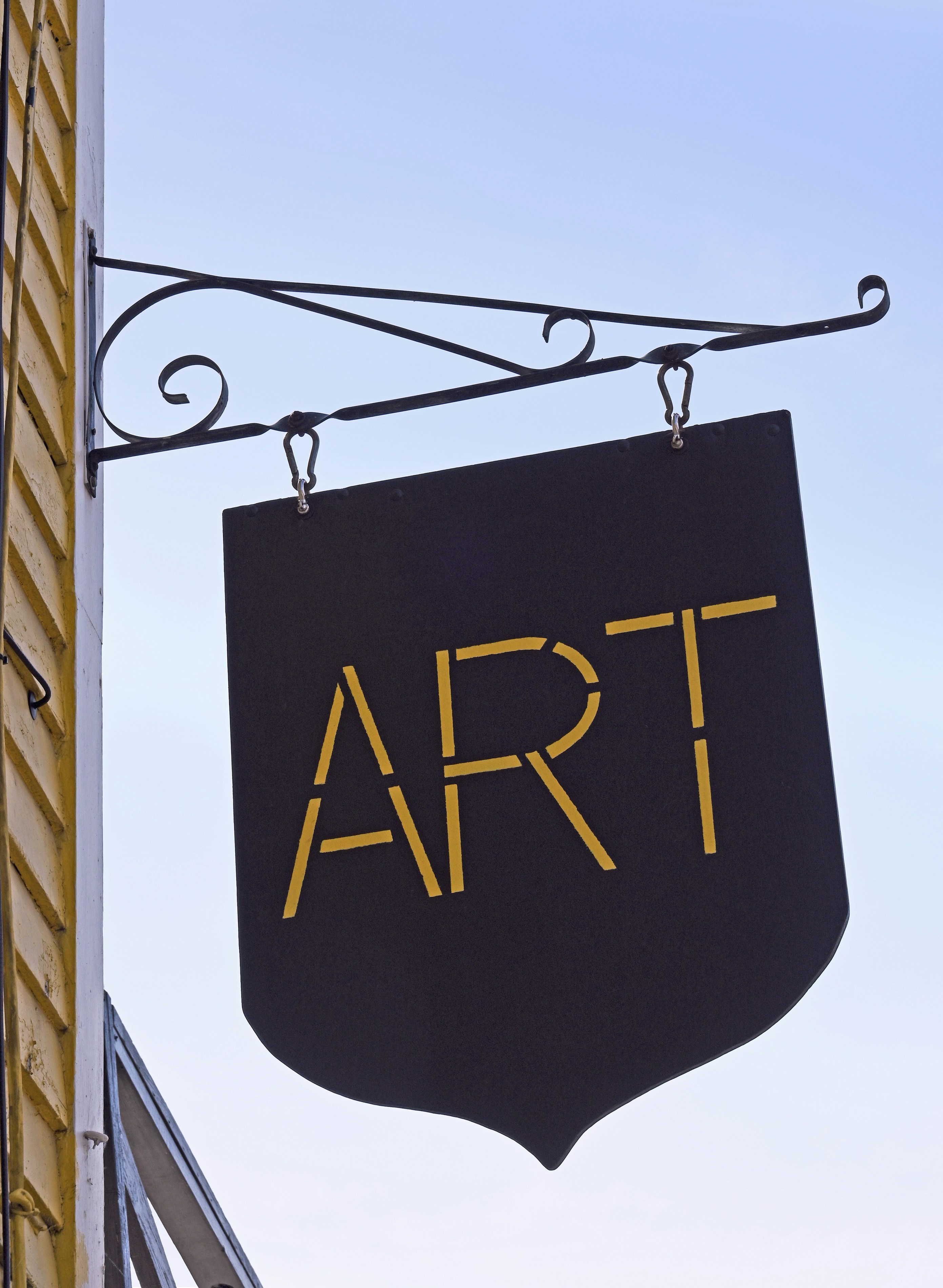 Art gallery sign hangs from a building.