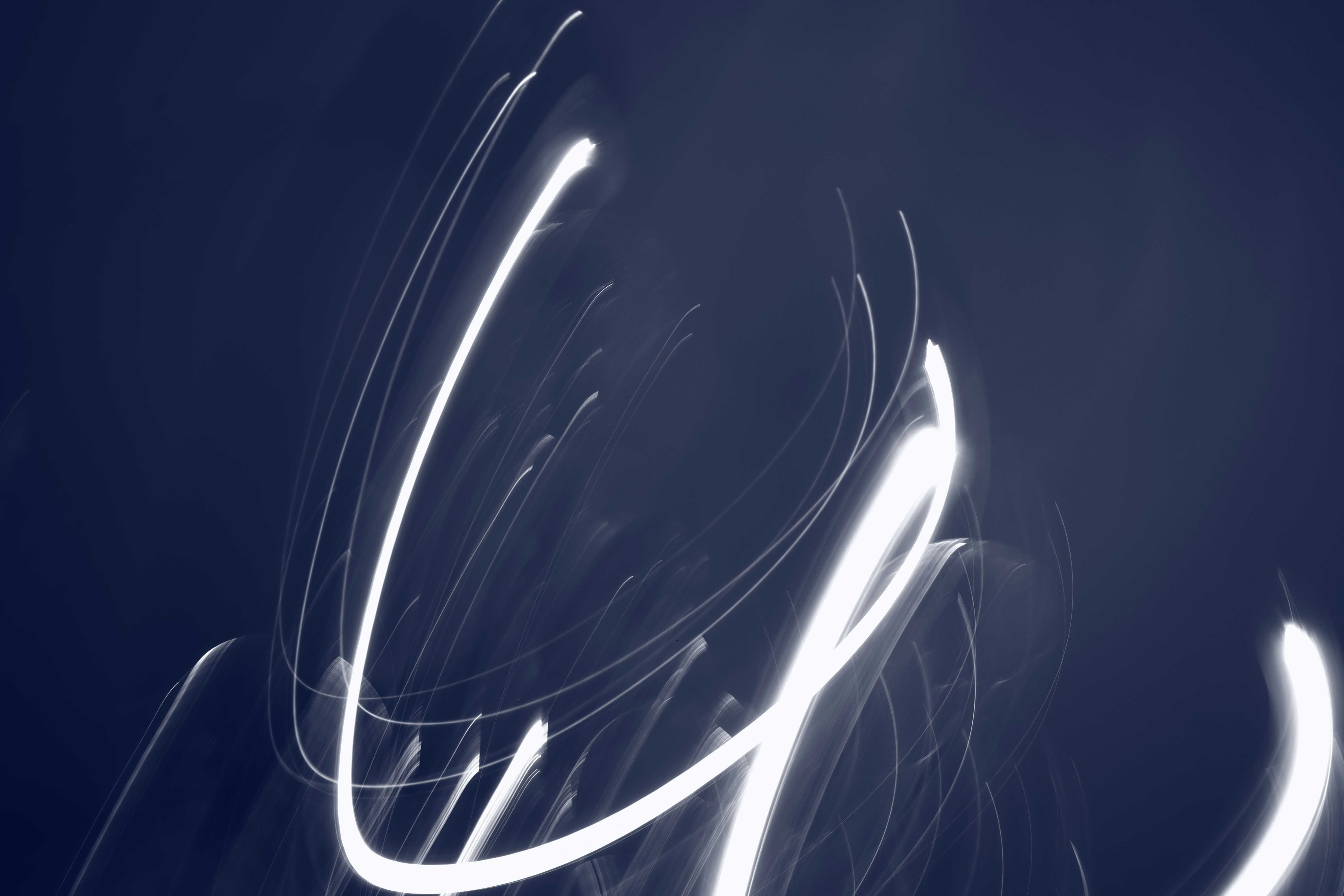 Abstract light trails against a dark background.