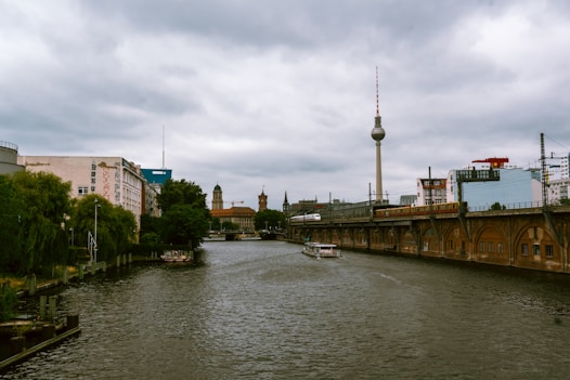 Berlin cityscape with river and cloudy skies.