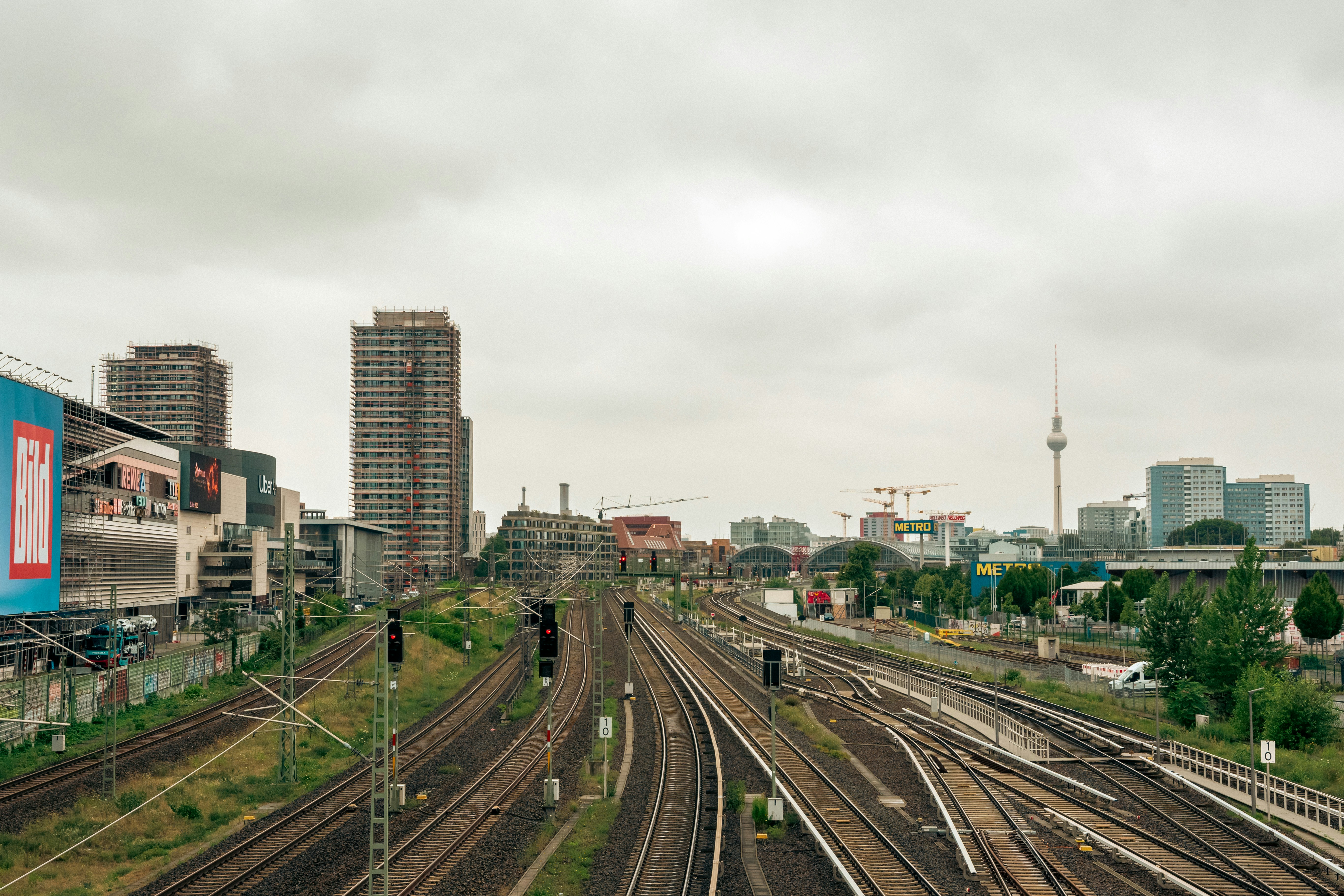I binari della ferrovia conducono a un paesaggio urbano nuvoloso.