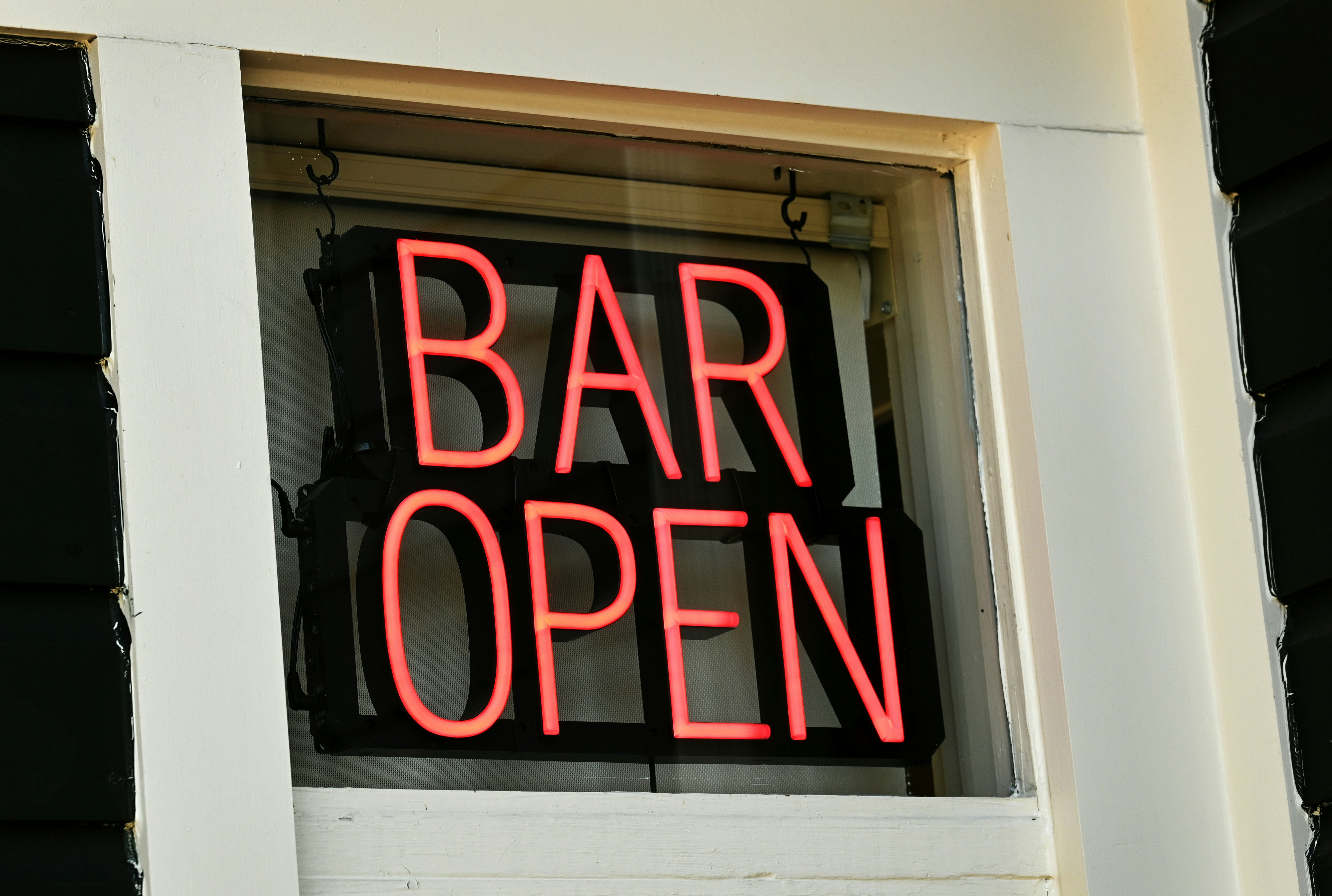 A neon sign announces that the bar is open.
