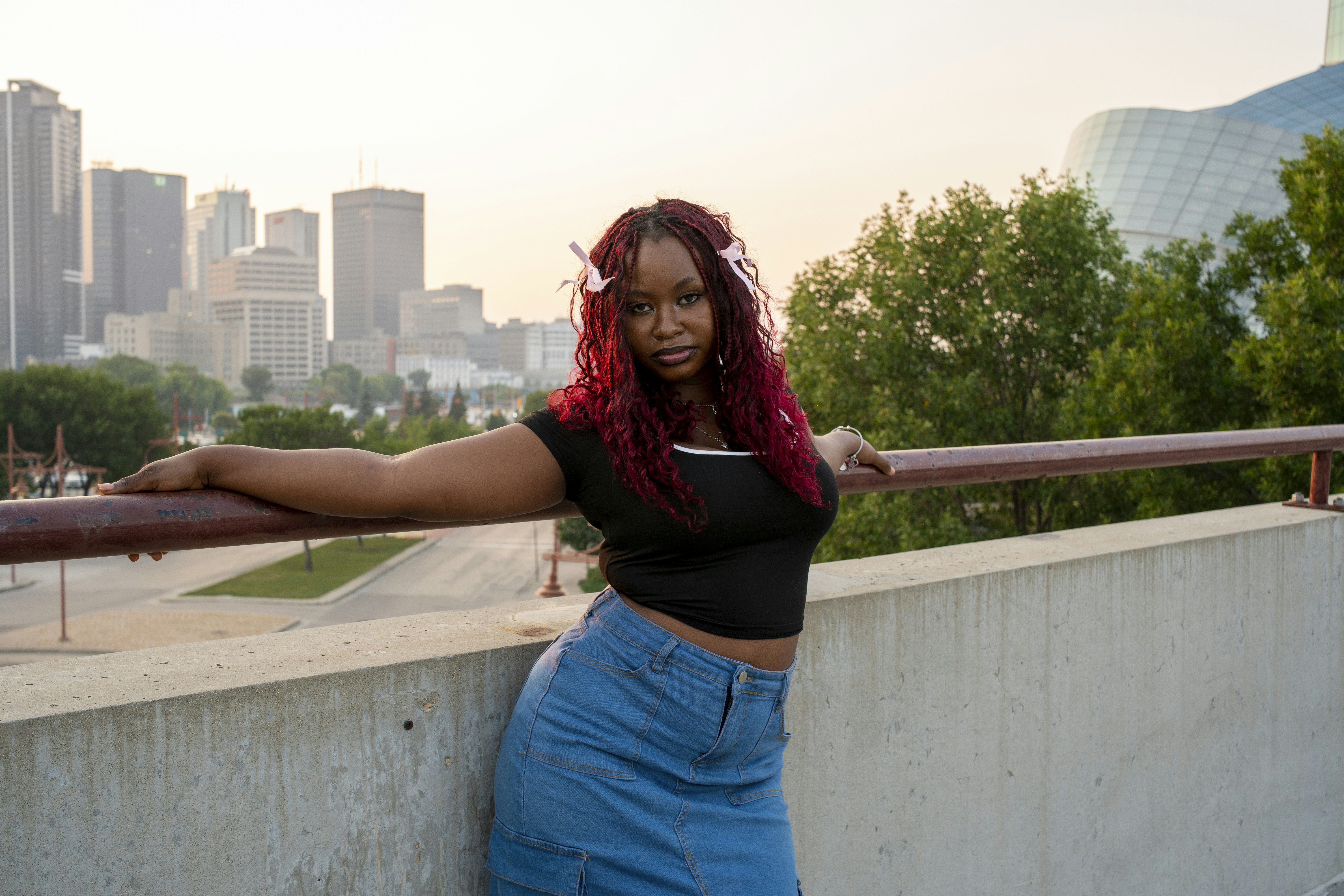 Woman posing against the backdrop of a city.