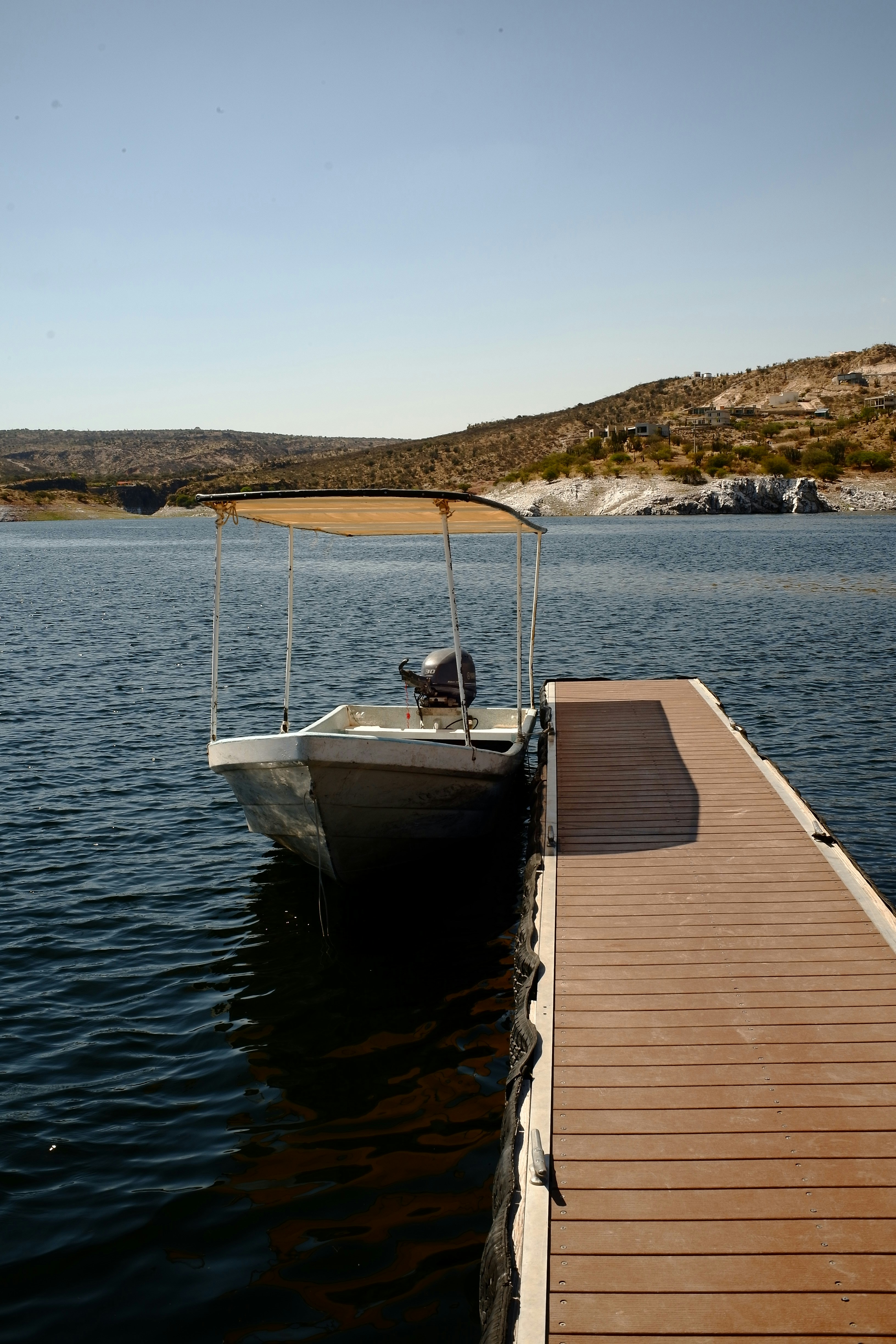 Ein Boot ist an einem Holzsteg auf einem See festgemacht.
