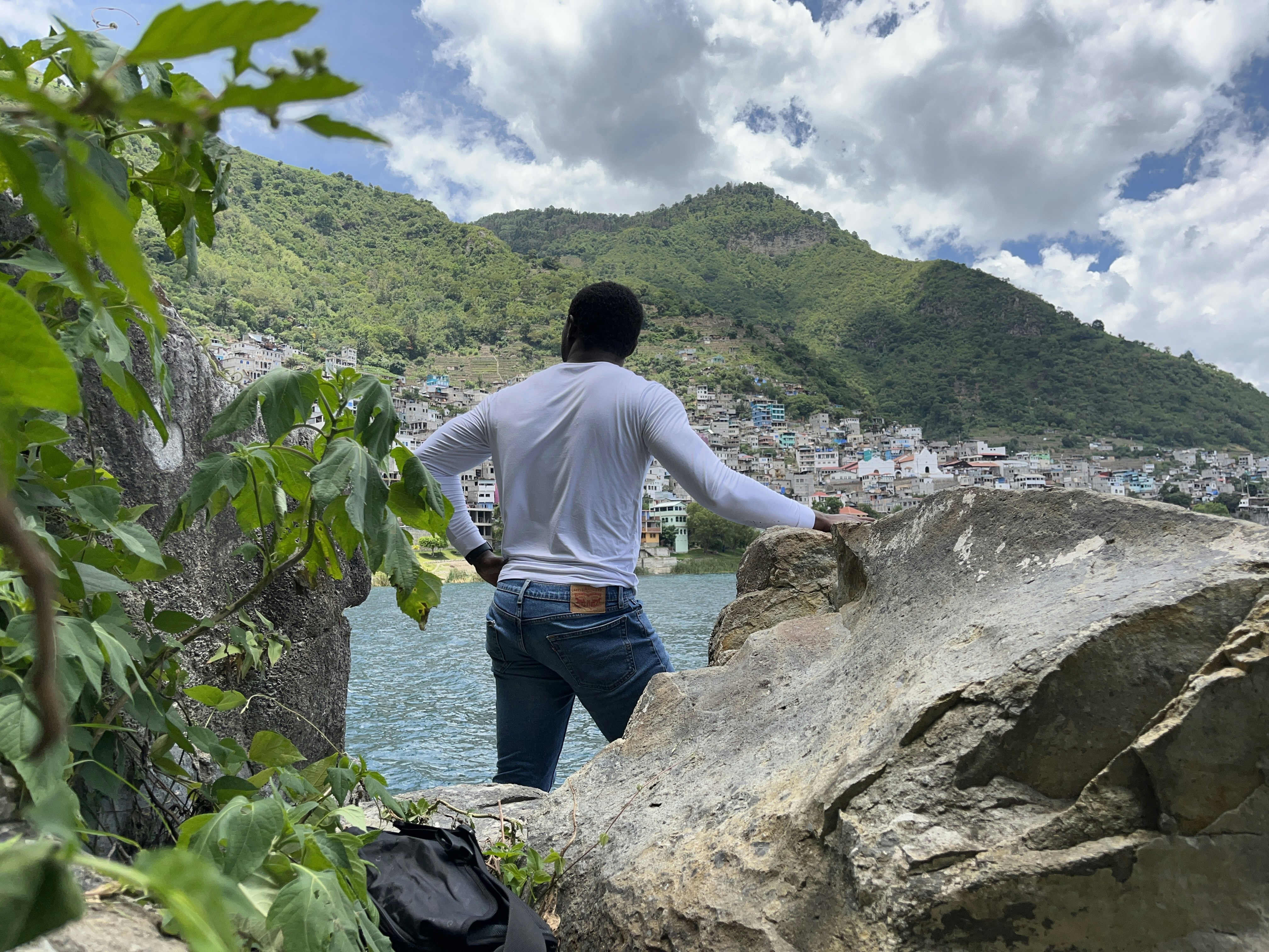 Man looks out at water and mountain view.