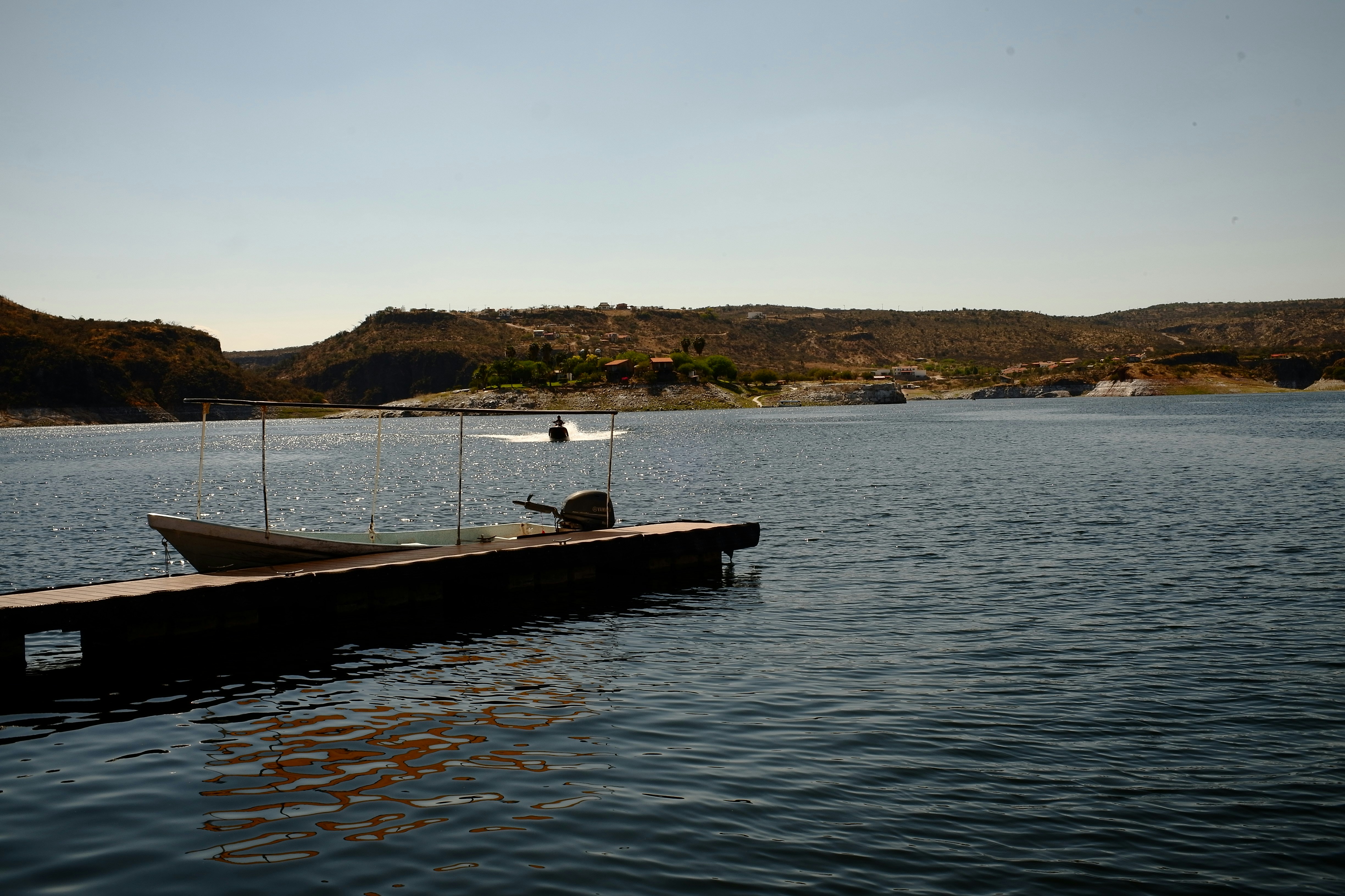 Ein Boot legt an einer Anlegestelle an einem See an.
