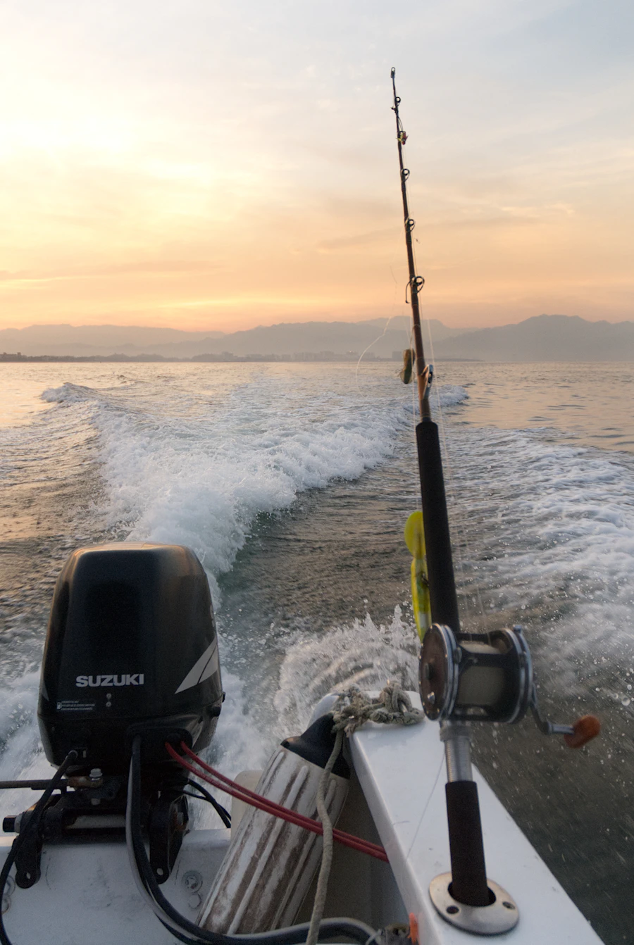 Fishing boat cruising on the water at sunset