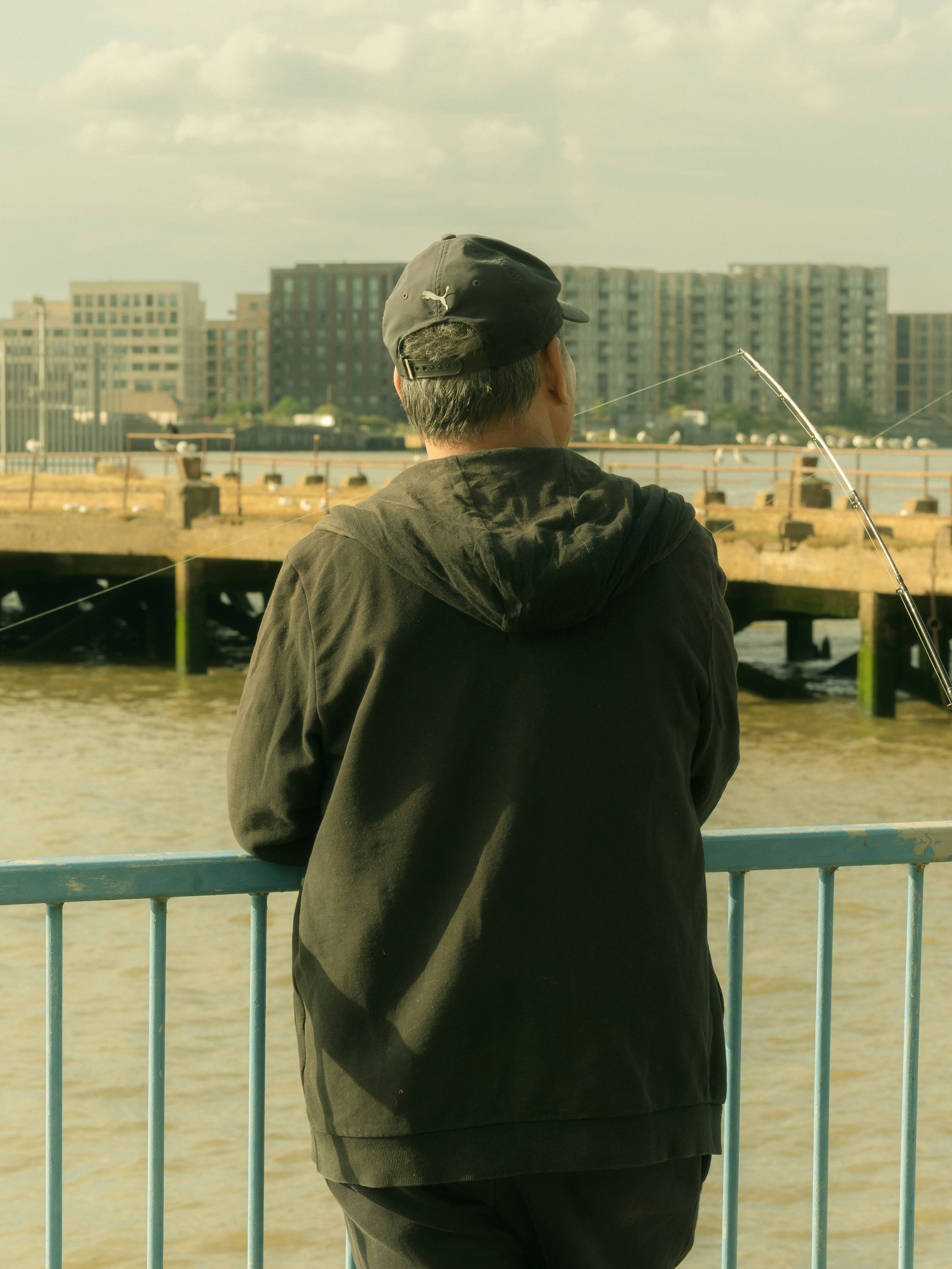 Une personne se tient debout et regarde au-dessus de l’eau.