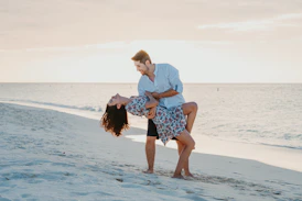 Una pareja baila románticamente en una playa soleada.