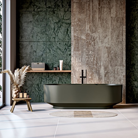 A modern bathroom with green marble and bathtub.