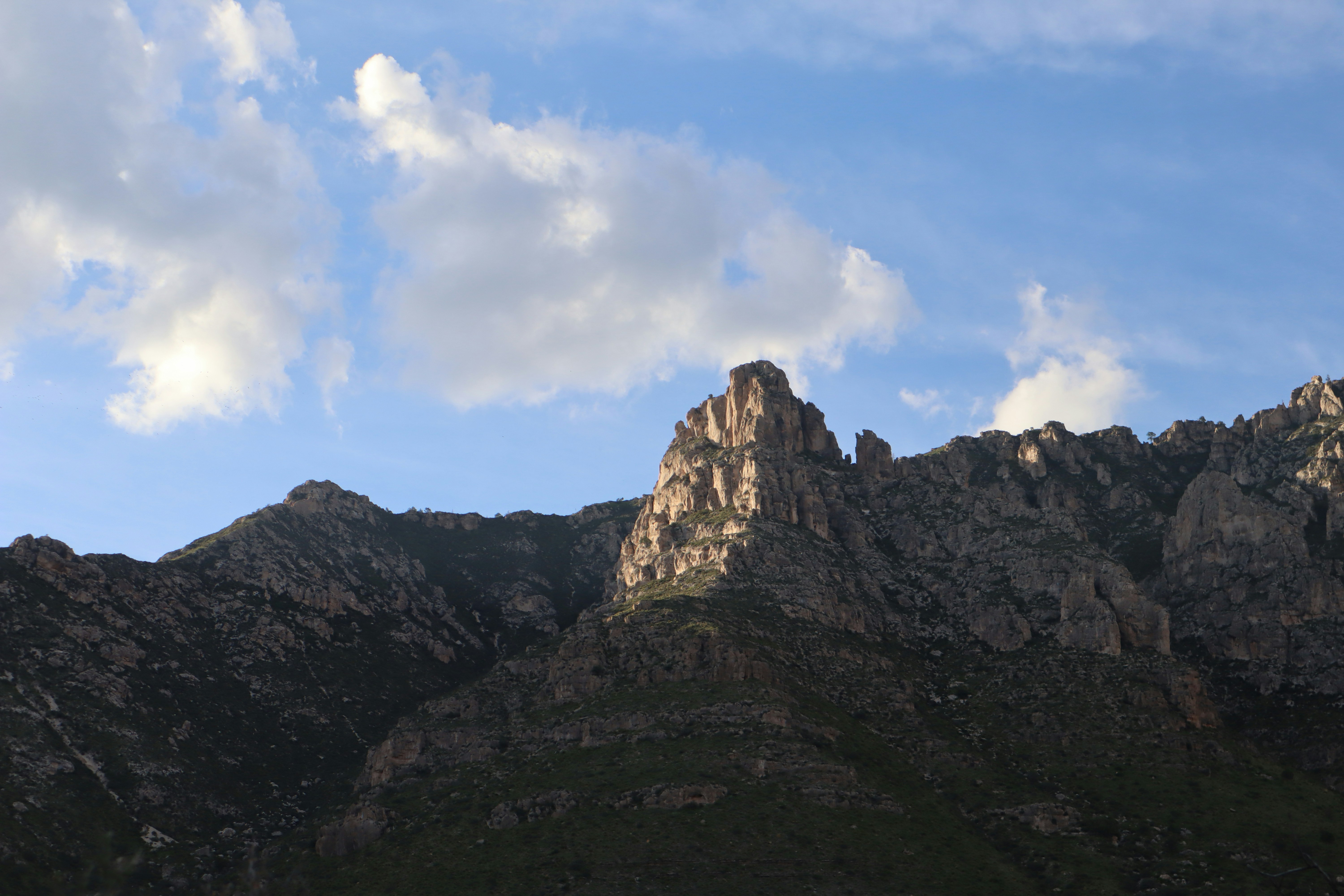 Mountains rise under a cloudy sky.