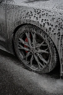 A car is covered in thick cleaning foam.