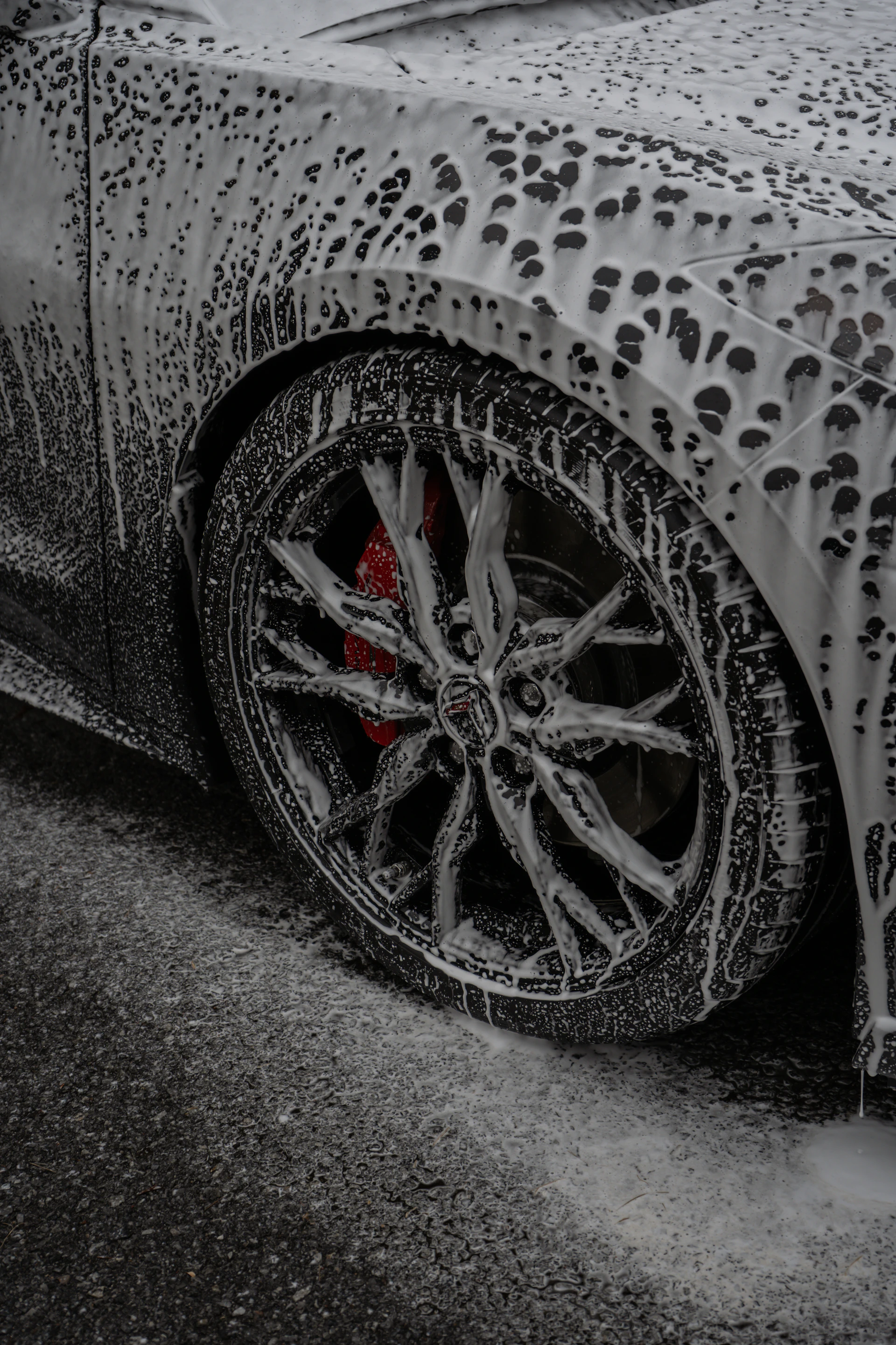 A car is covered in thick cleaning foam.
