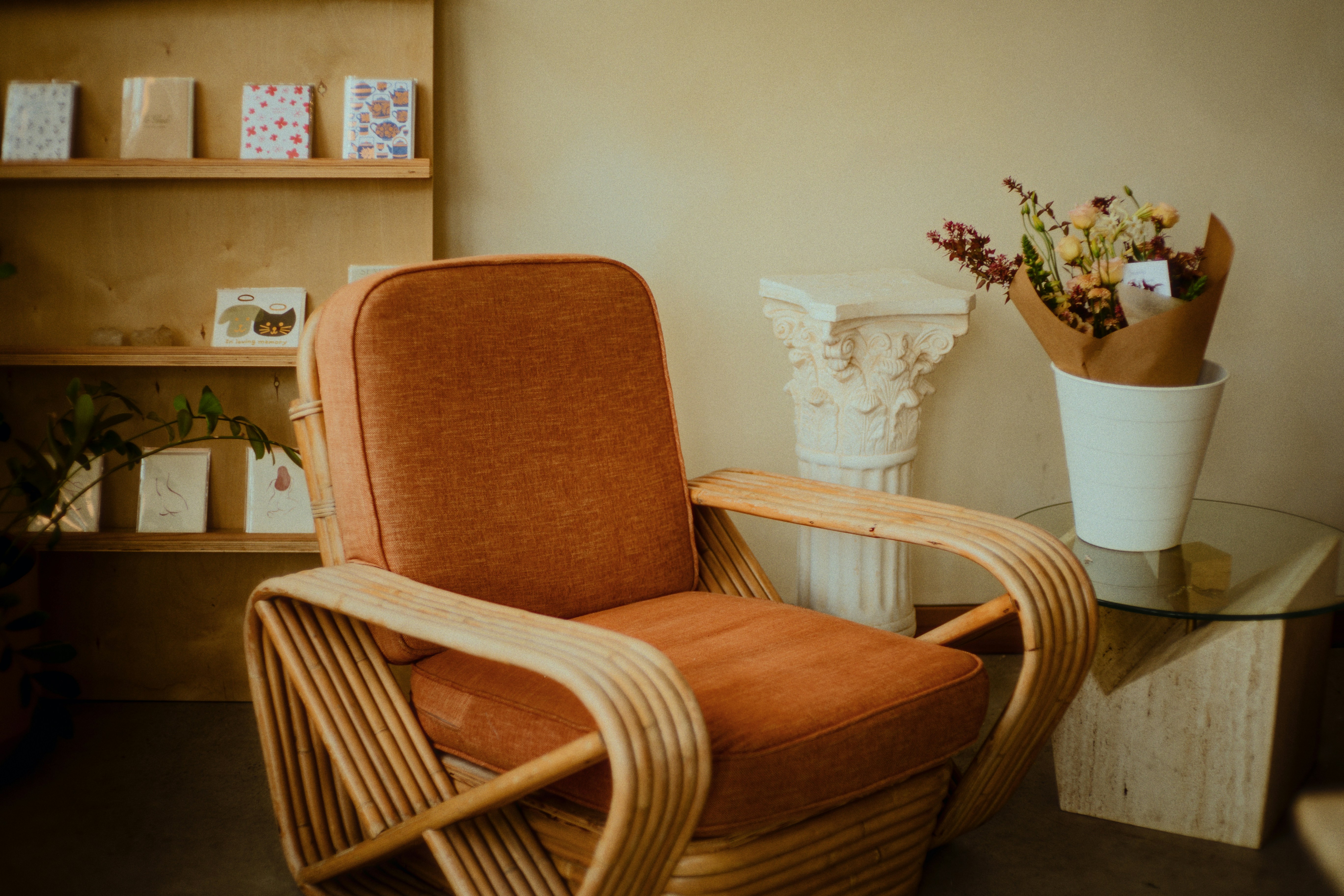 Cozy chair and floral arrangements in a warm room.