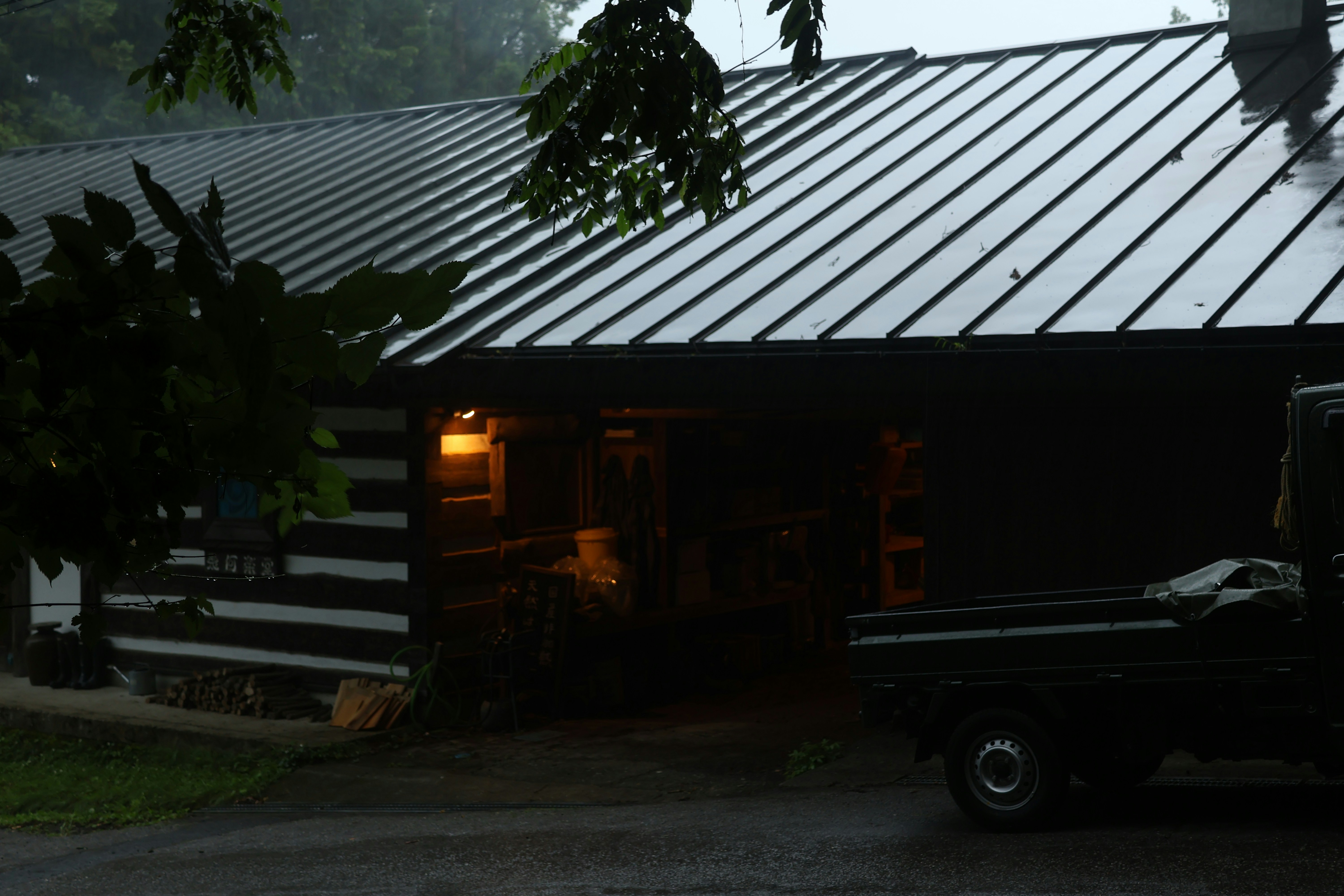 A rustic cabin is seen in the rain.