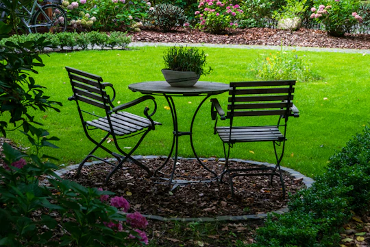 A table and chairs sit in a lush garden.