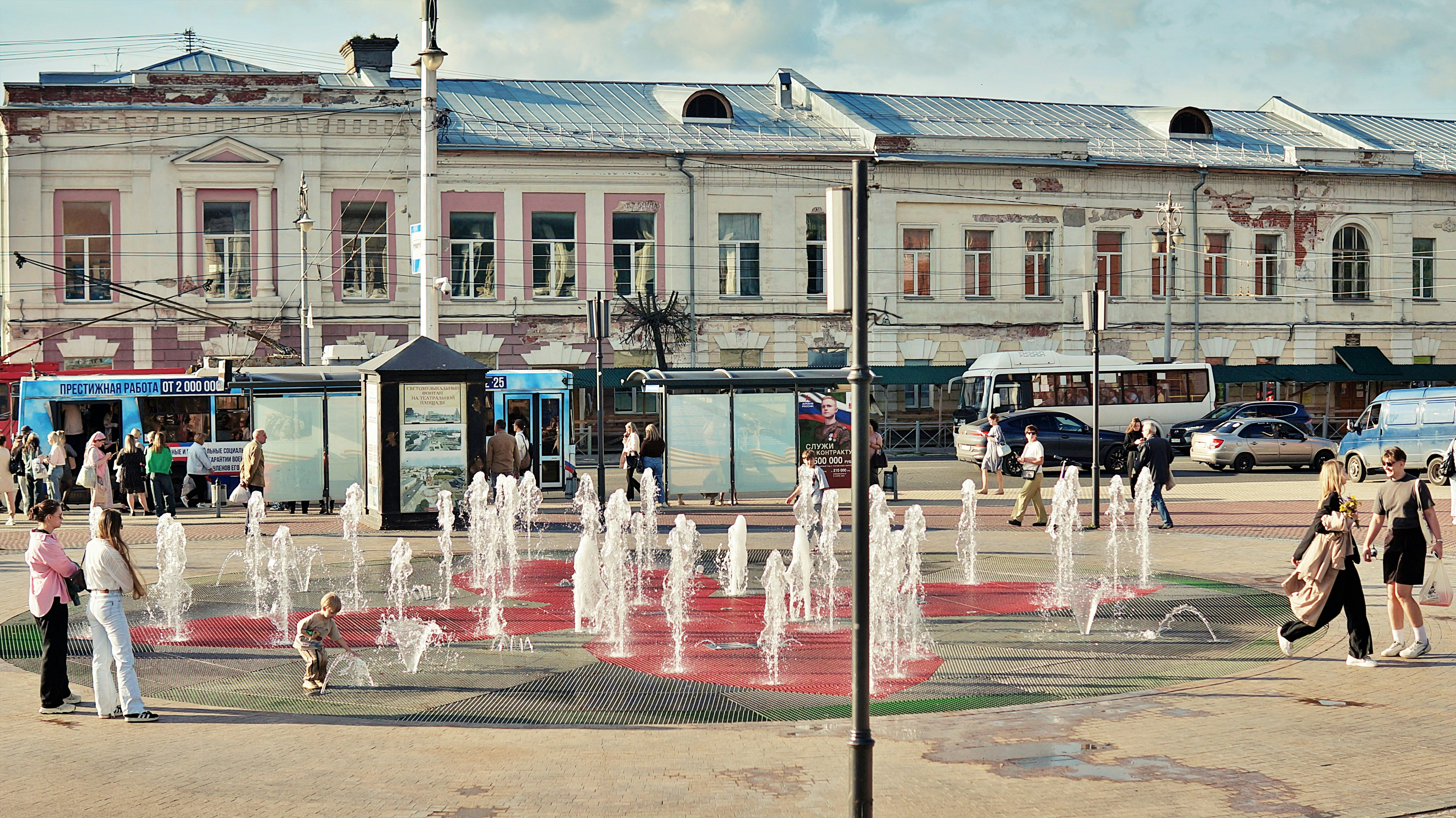 People enjoy a fountain on a sunny day.