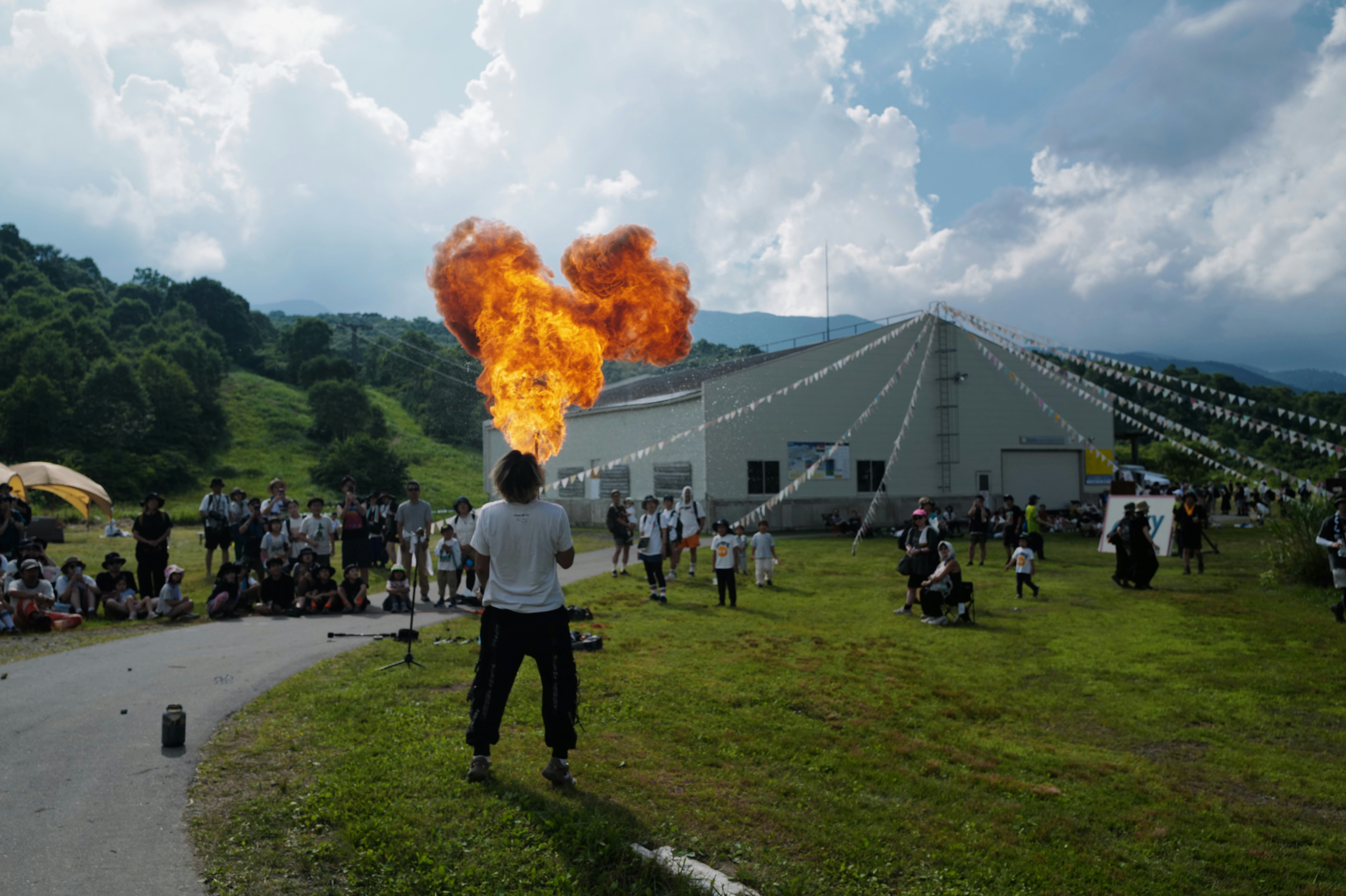 Man breathes fire in front of a crowd.