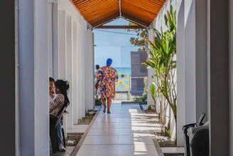 People walk down a long, light-filled corridor.