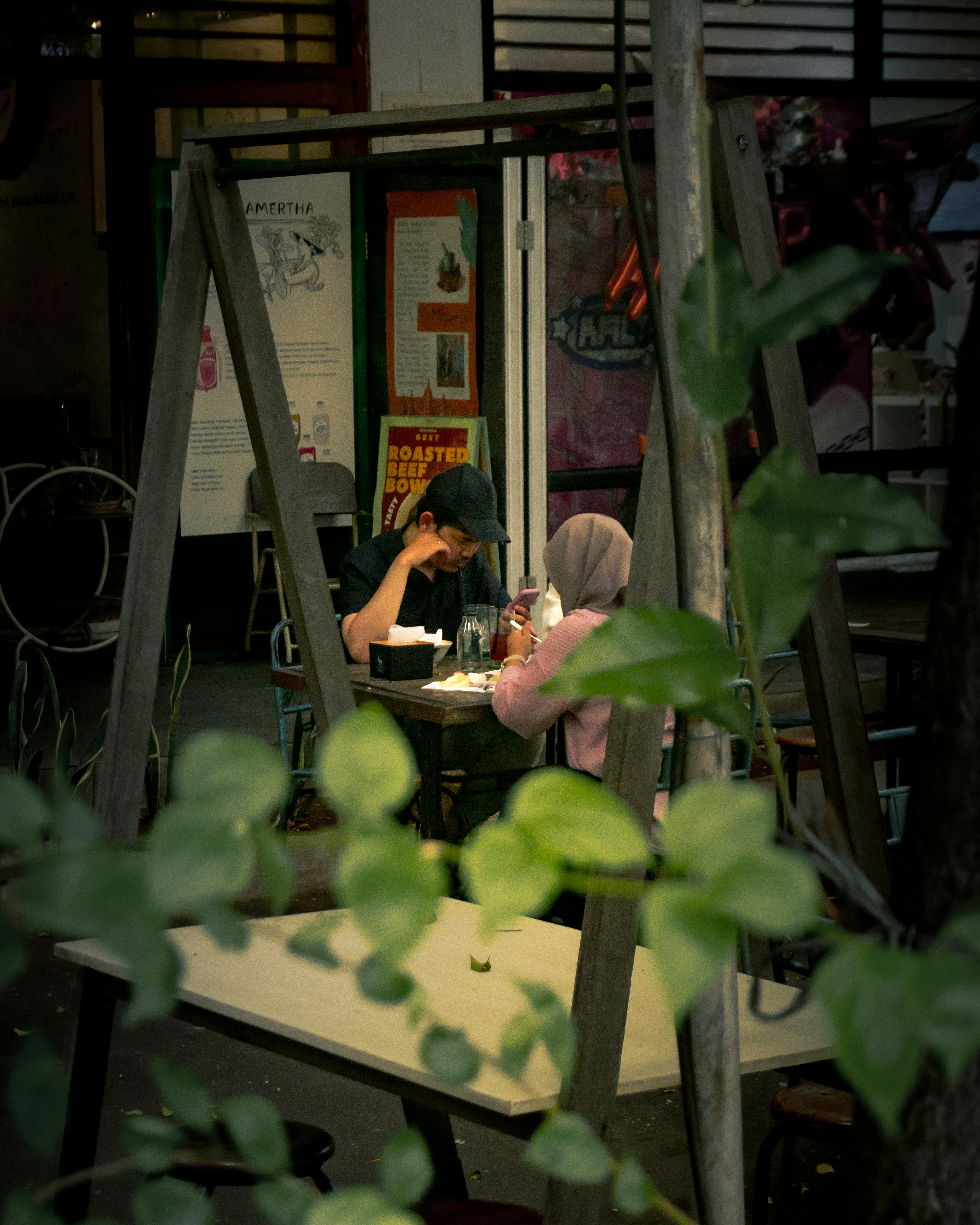 People sit at a table outside a cafe.