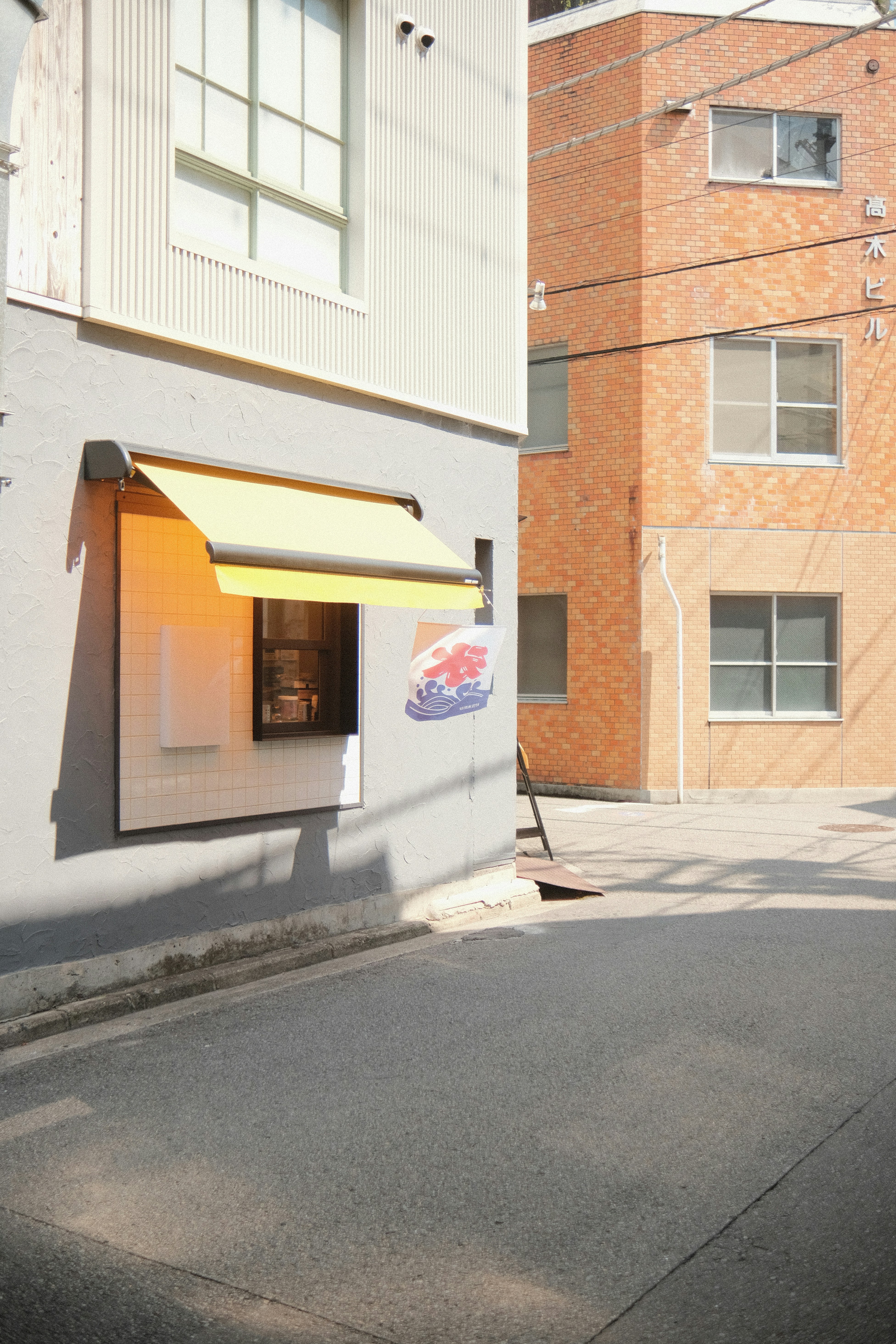 A sunny alley with a shop and buildings.