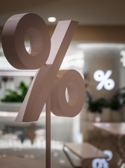 A large percentage sign stands in a store.