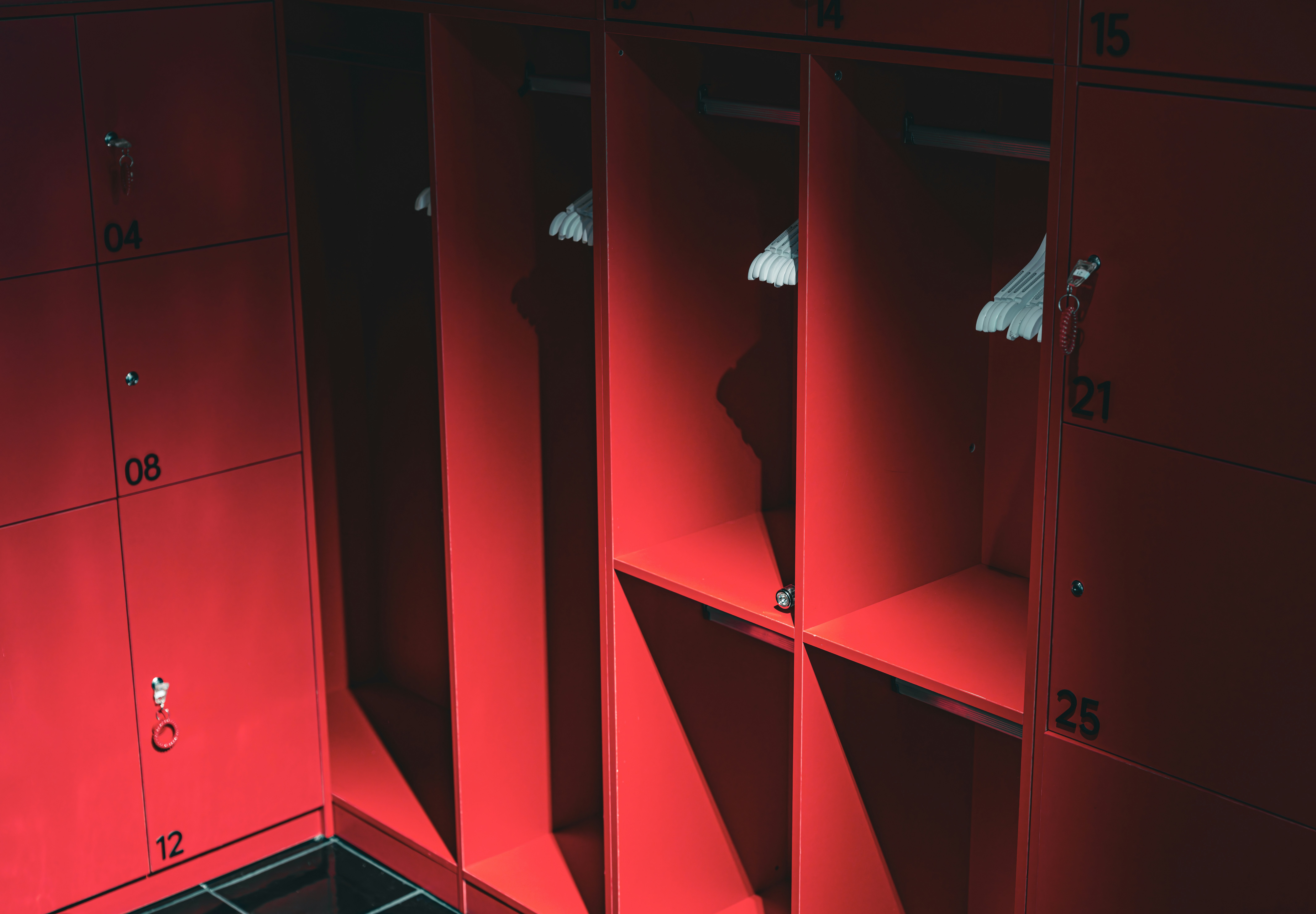 Empty red lockers with a few hangers.