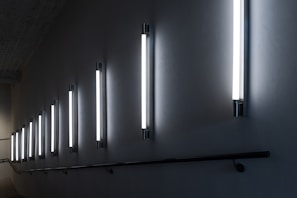 Fluorescent lights illuminate a dark stairwell.
