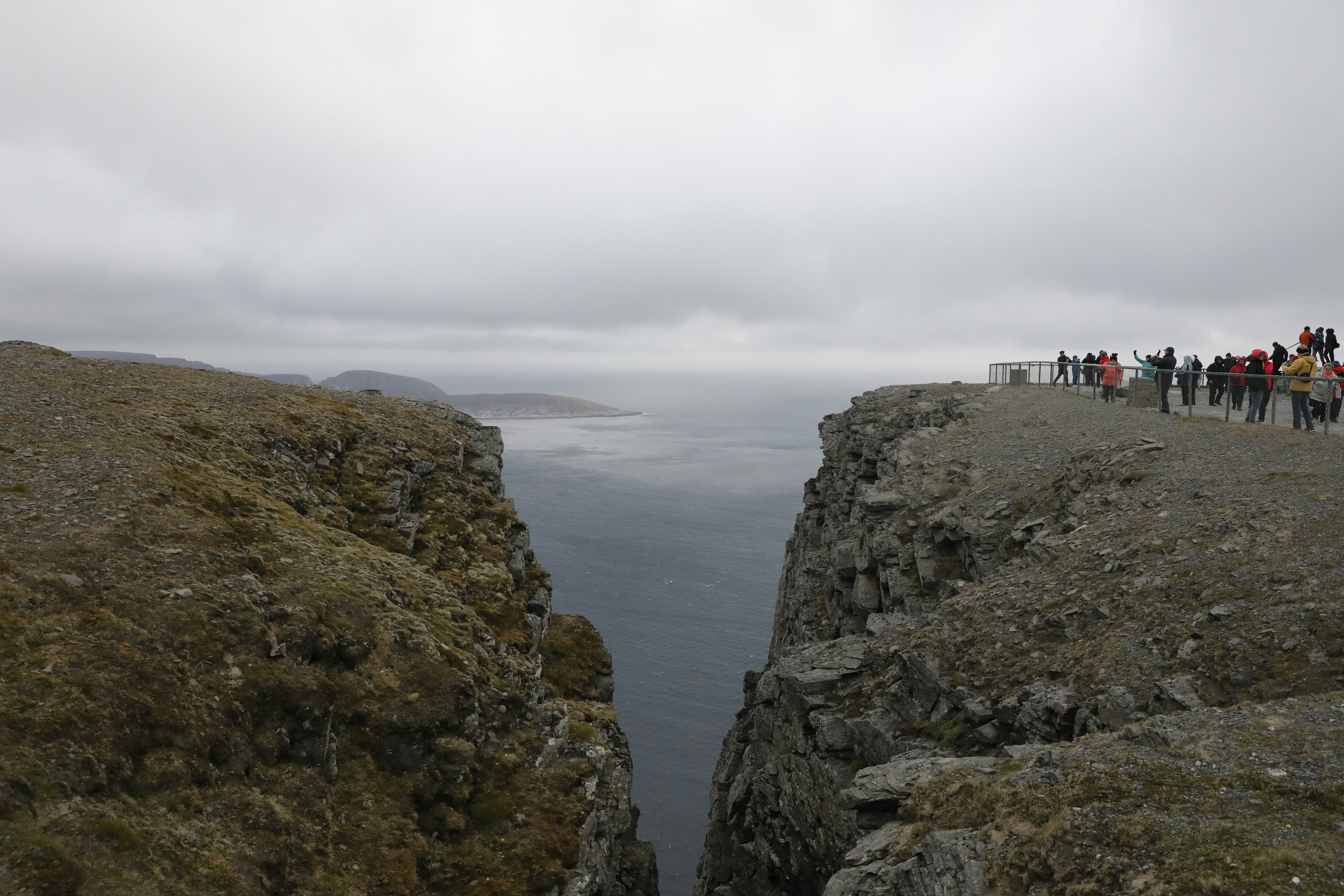 Cliffside views of the ocean under a cloudy sky.