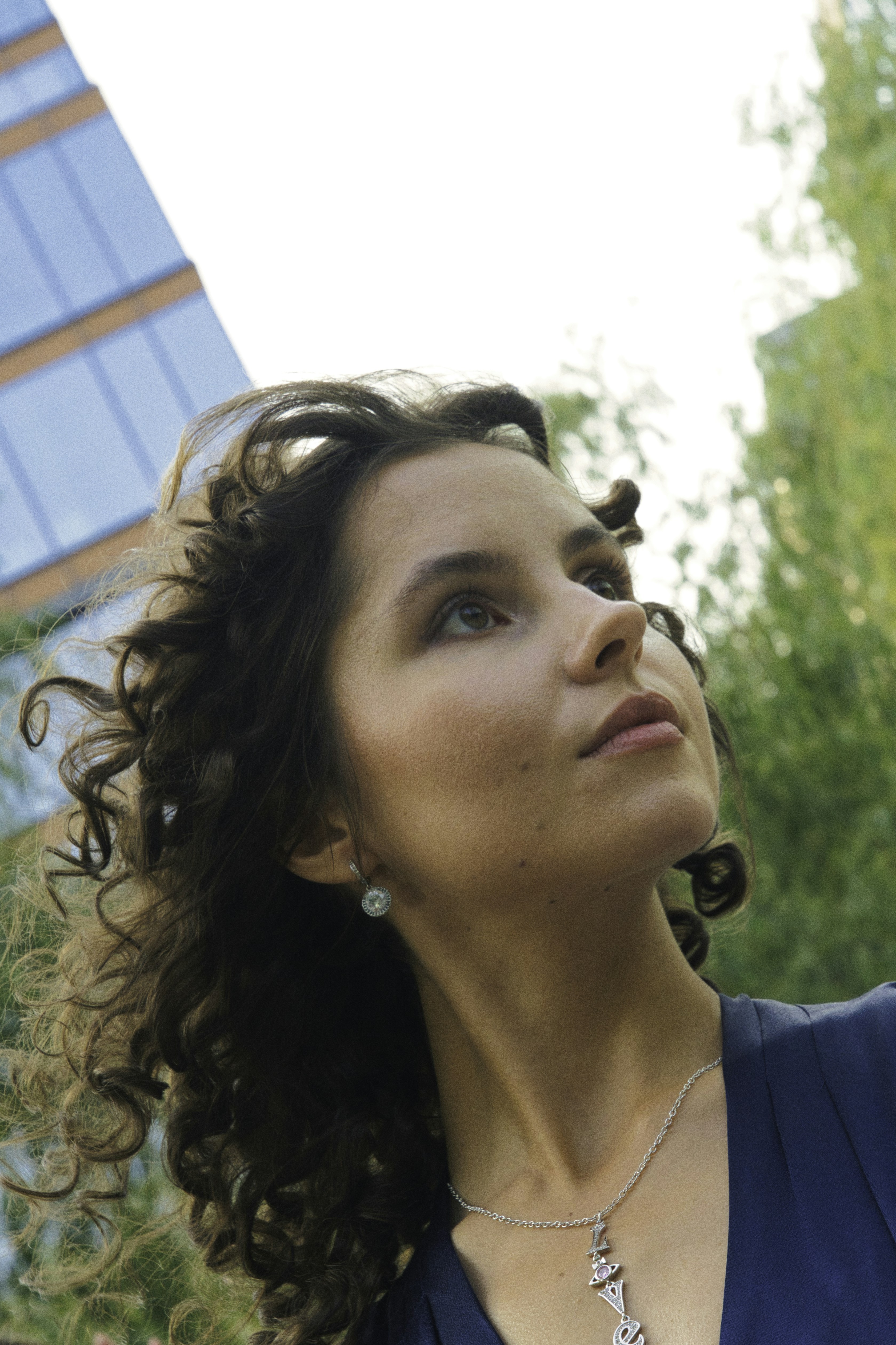 A woman looks up in an urban setting.