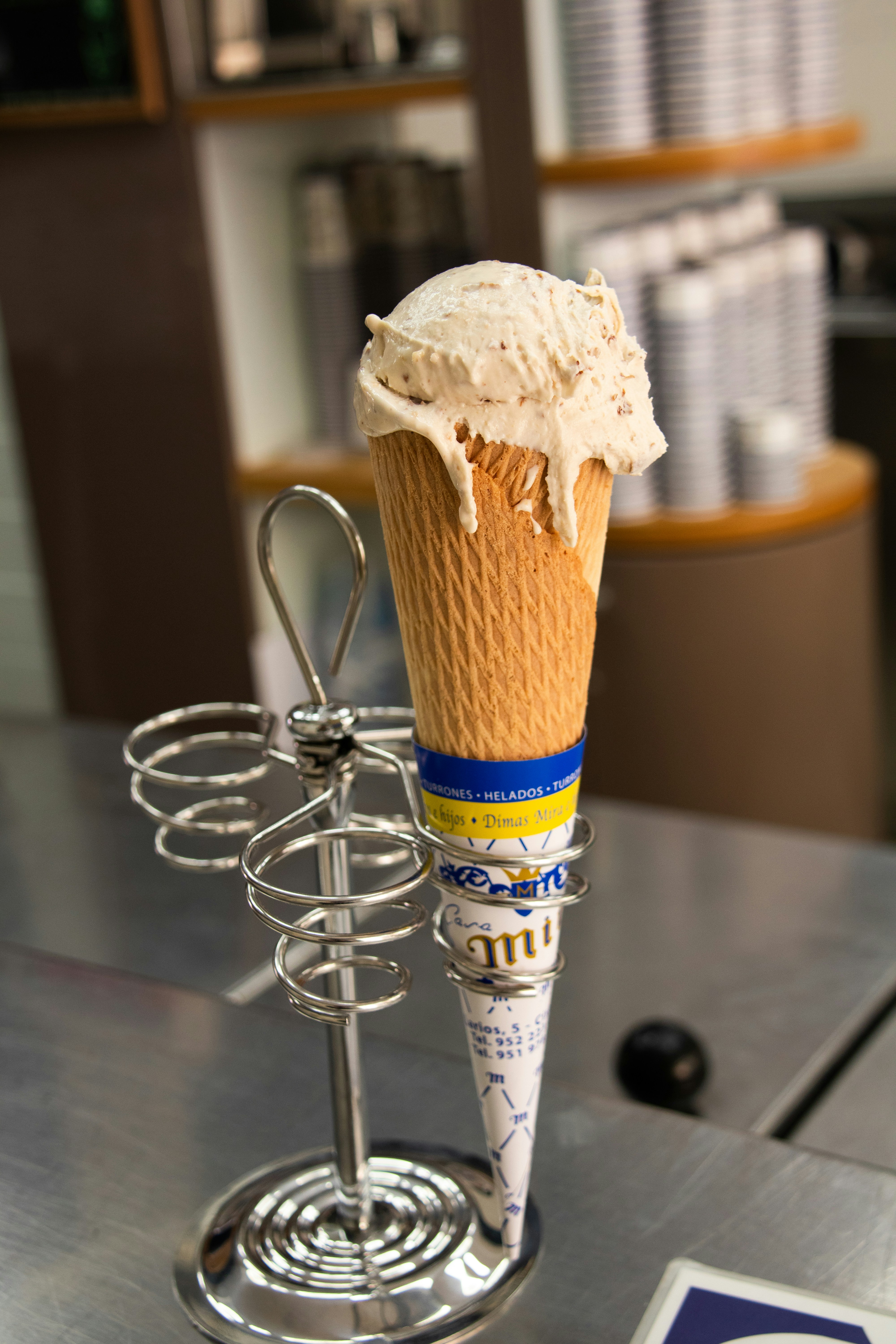 맛있는 아이스크림 콘이 금속 스탠드에 놓여 있습니다.