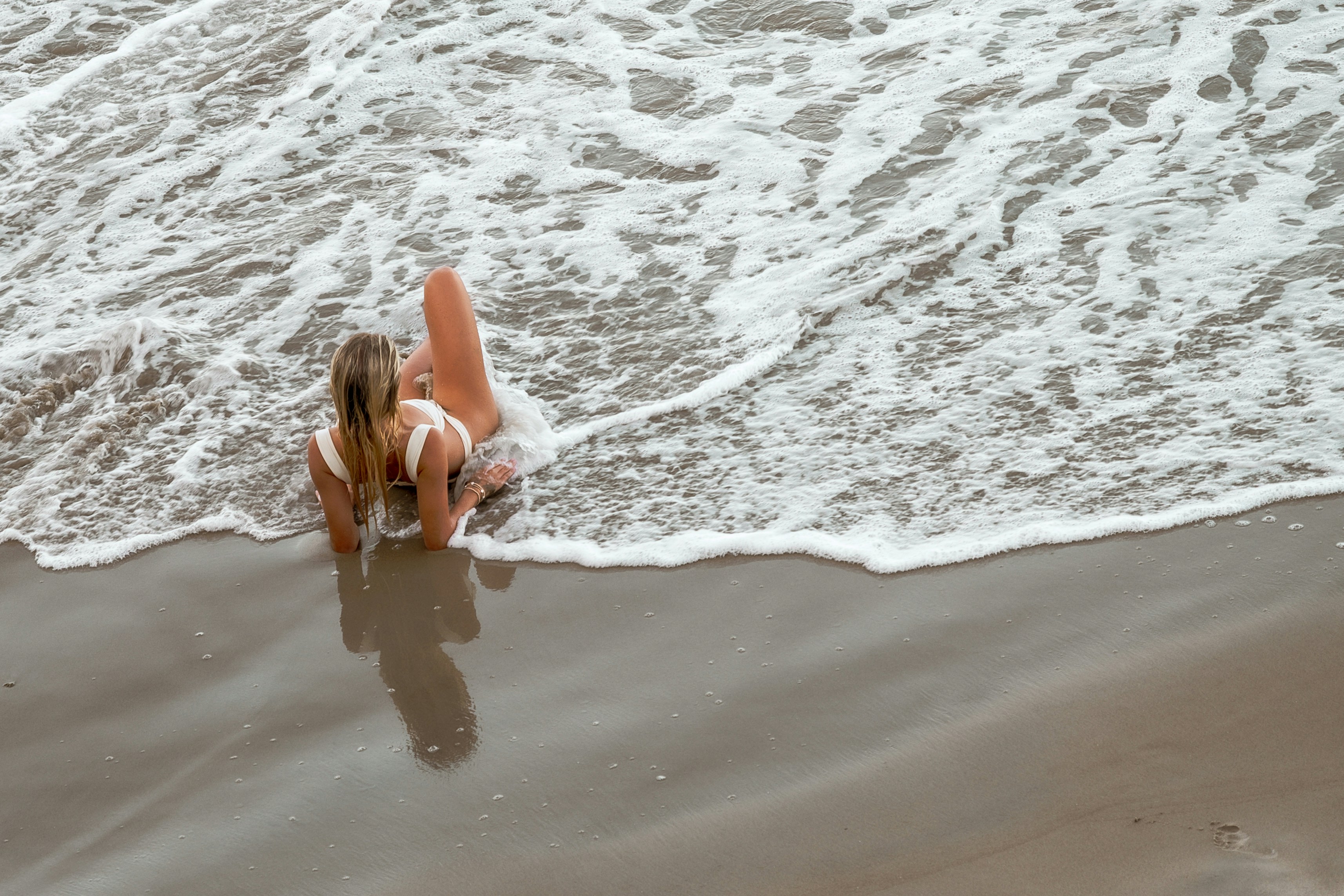 Woman on the beach, near the surf.