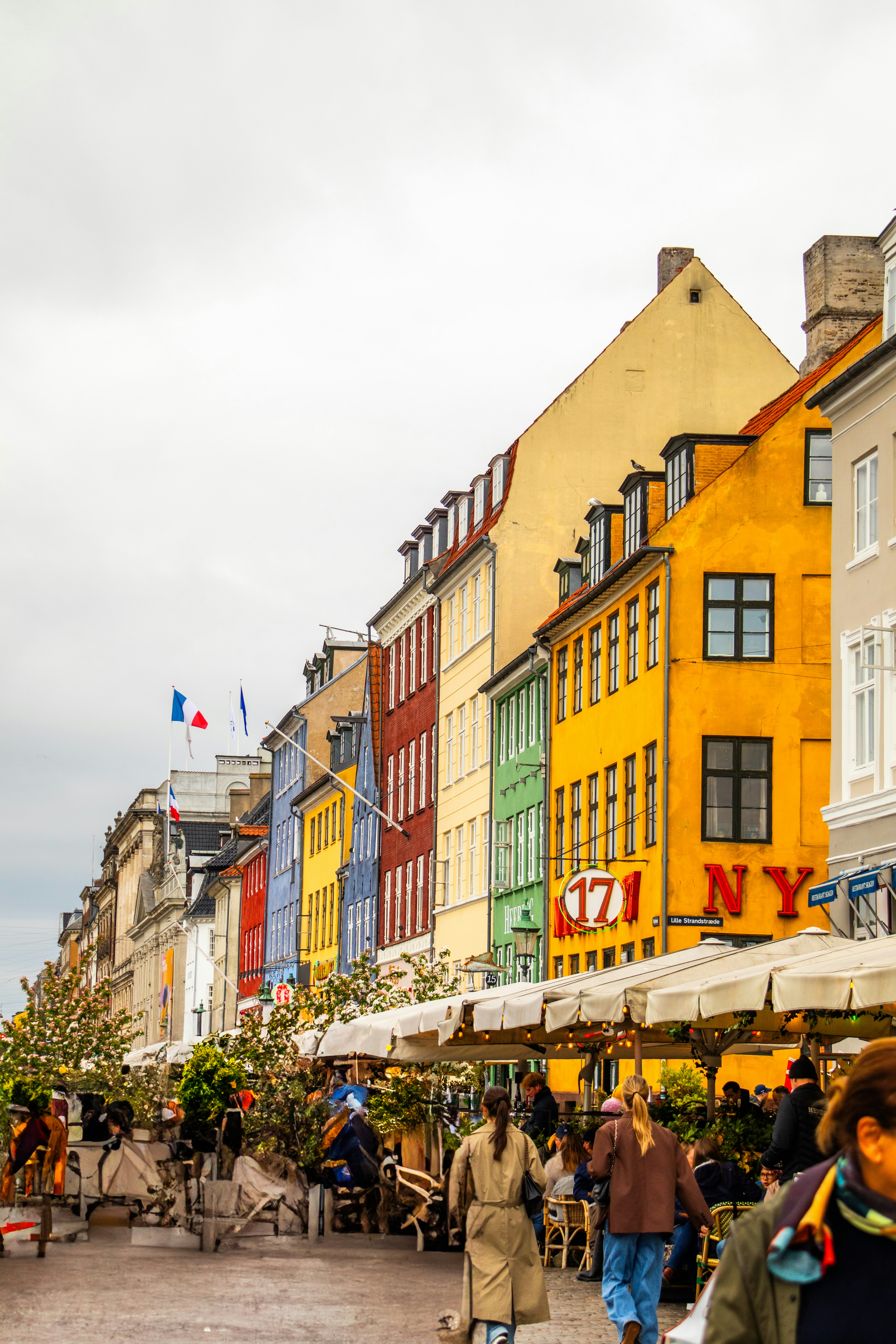Des bâtiments colorés bordent une scène de rue animée.