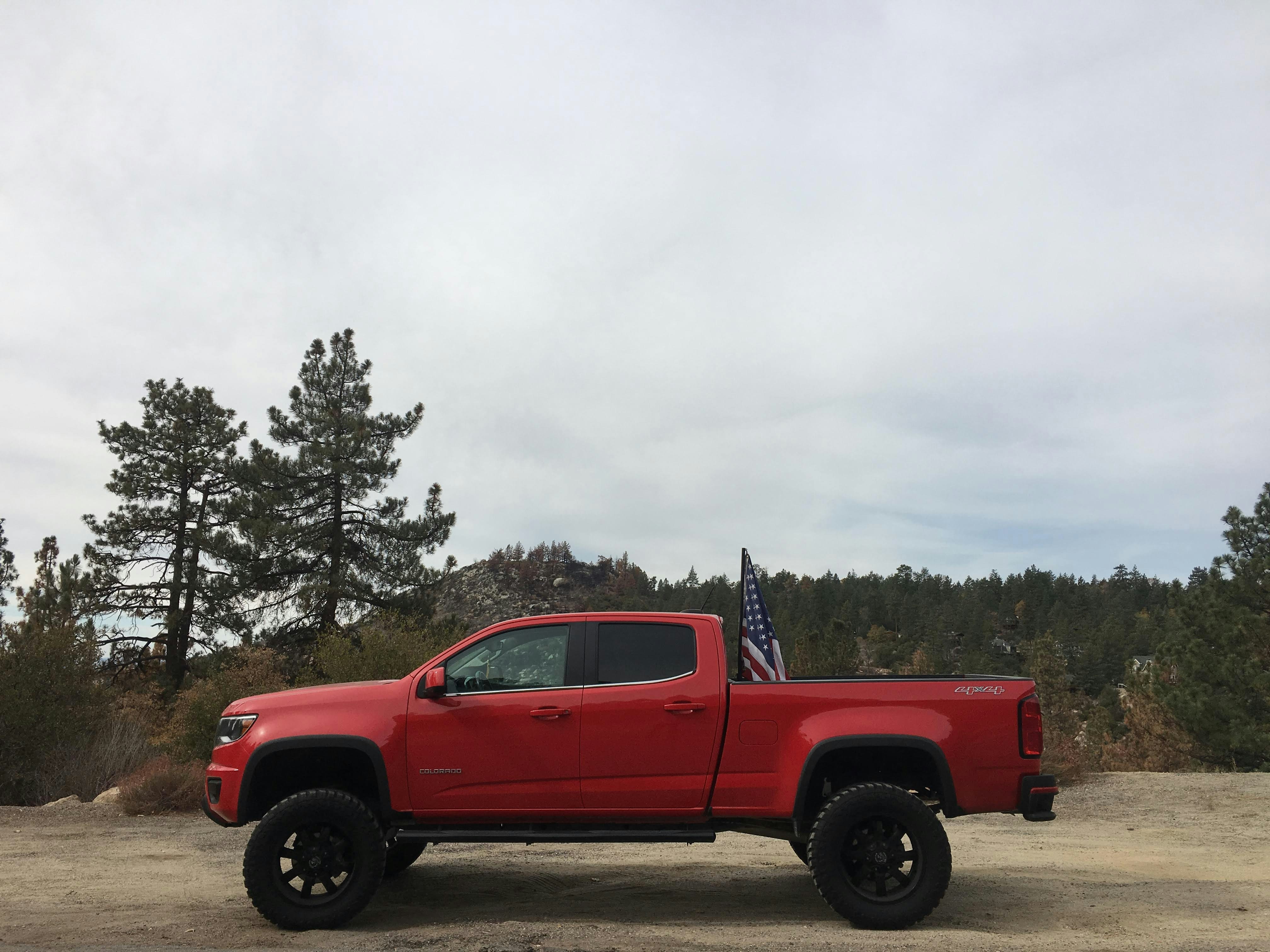 Red truck with an american flag on display.
