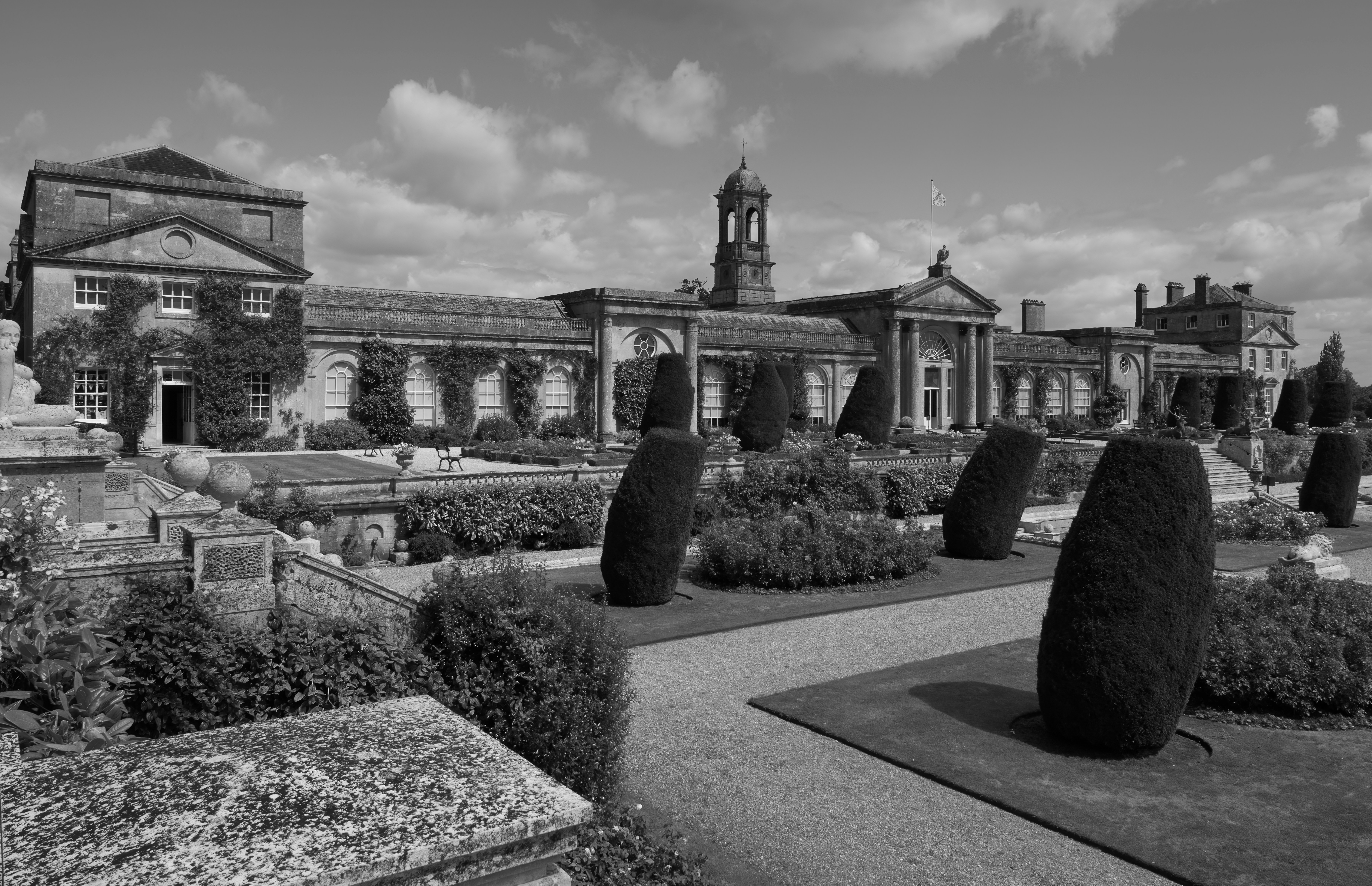 A stately home sits amidst formal gardens.