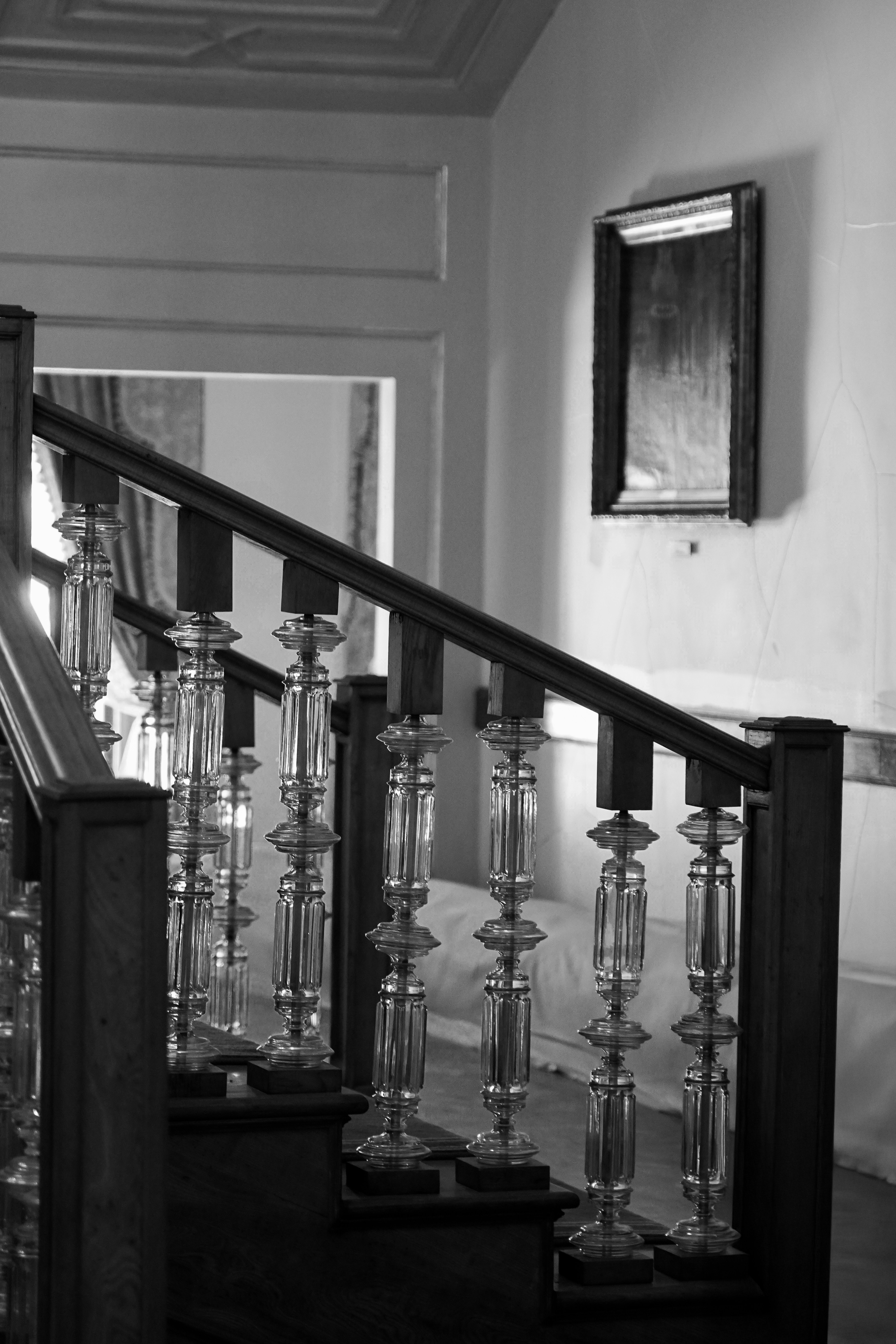 Elegant staircase with glass banisters in an old building.
