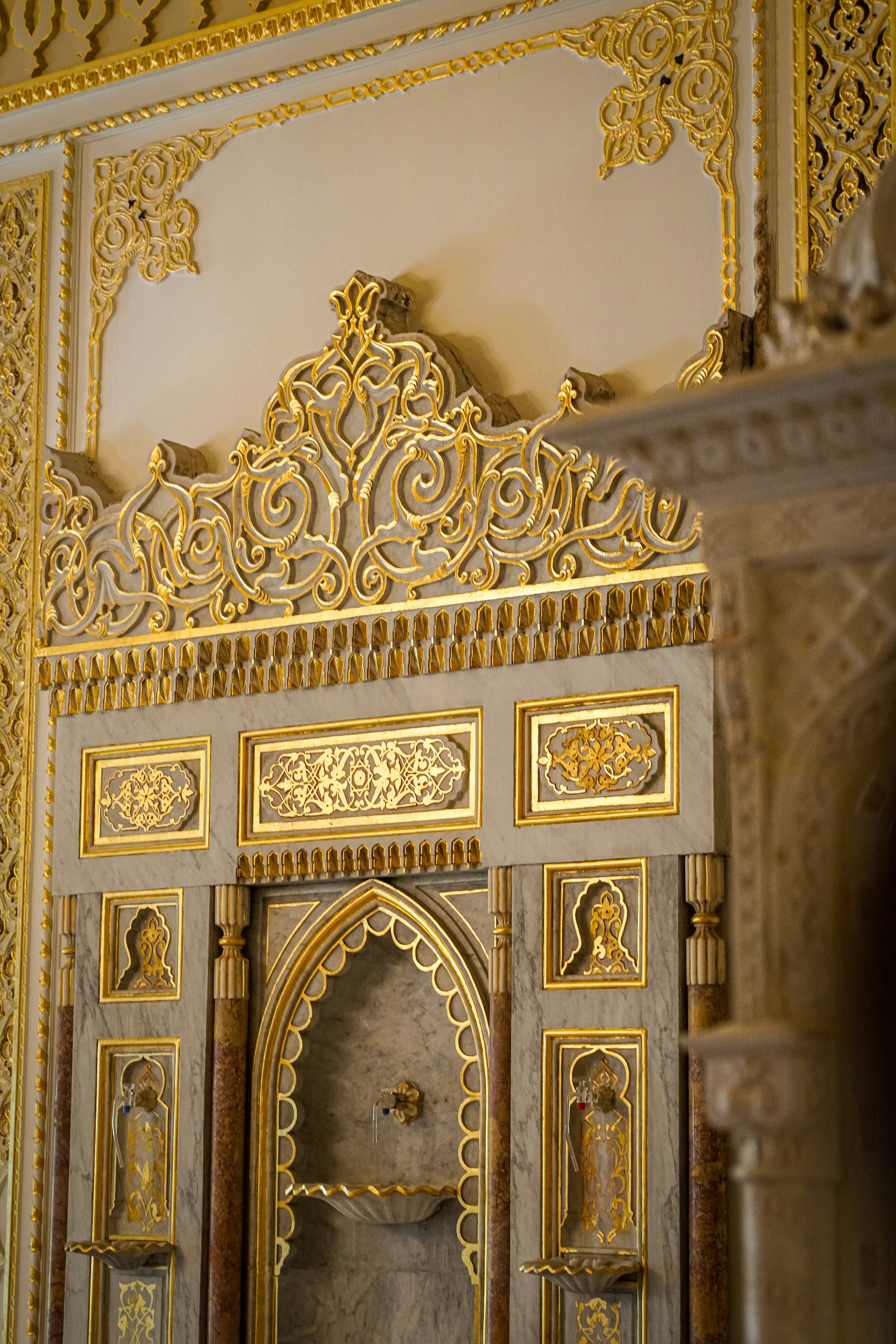 Gold-decorated wall detail inside of an ornate building.