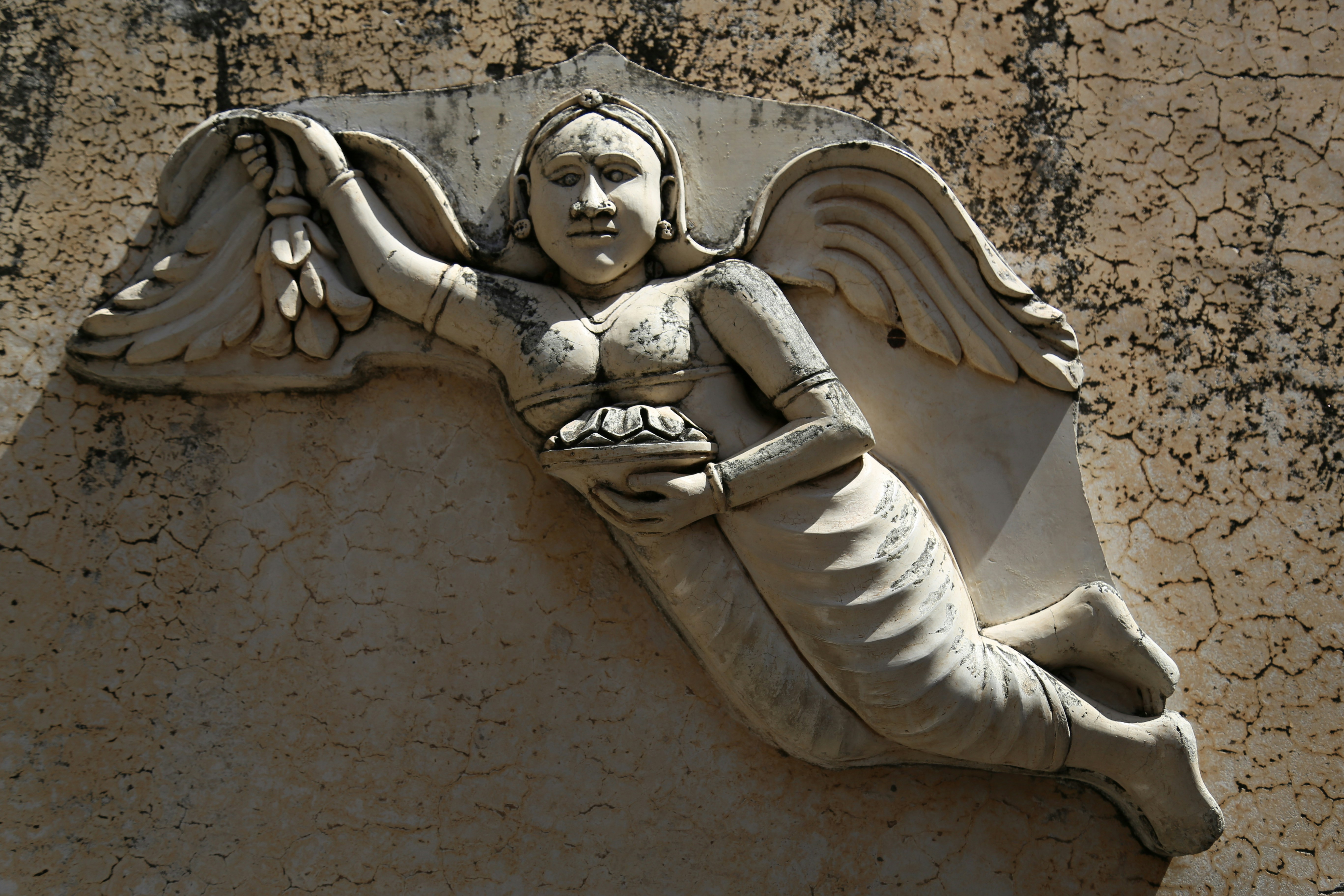 A stone sculpture depicts a winged figure.