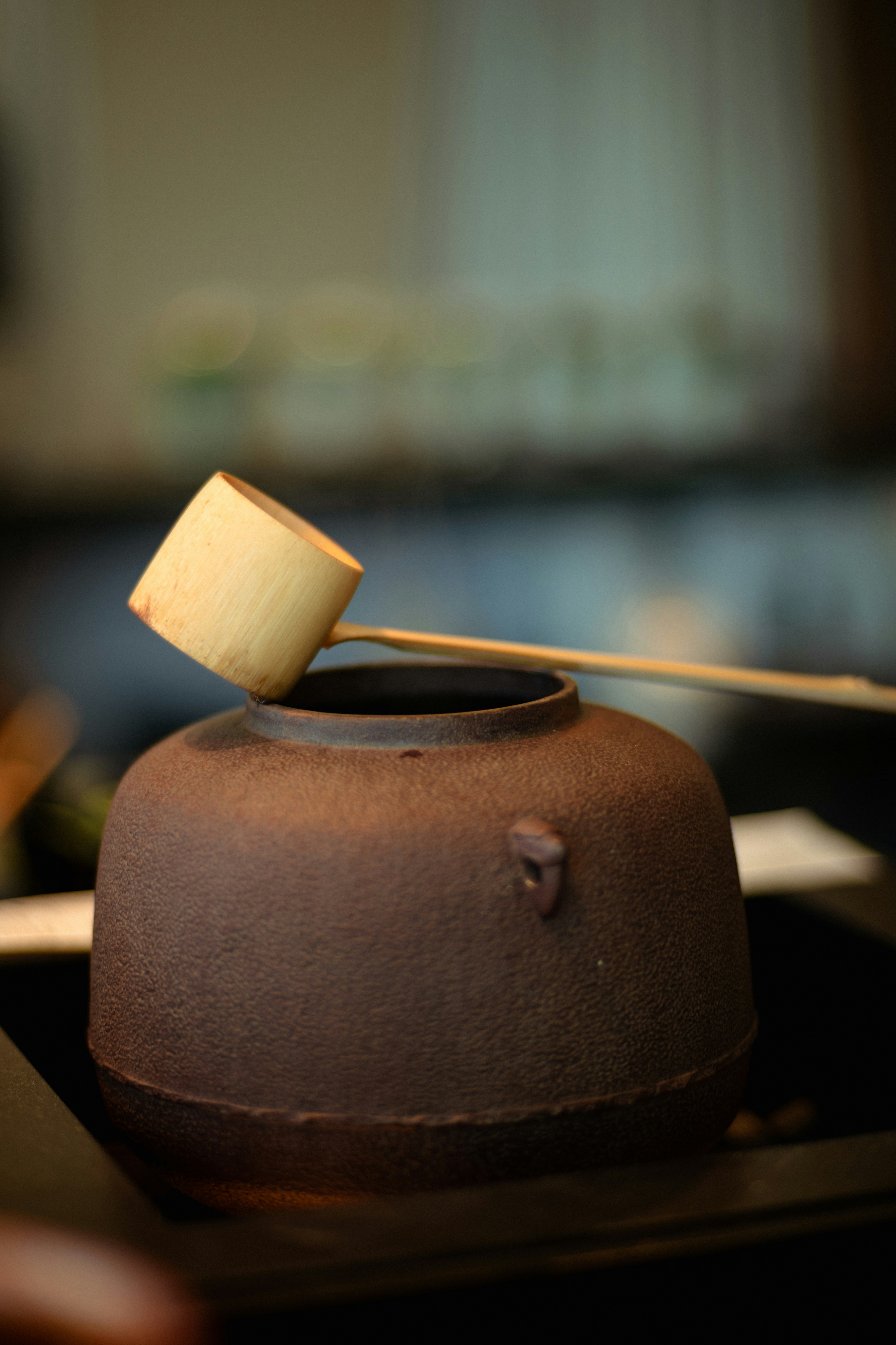 Bamboo ladle rests atop a traditional iron pot.